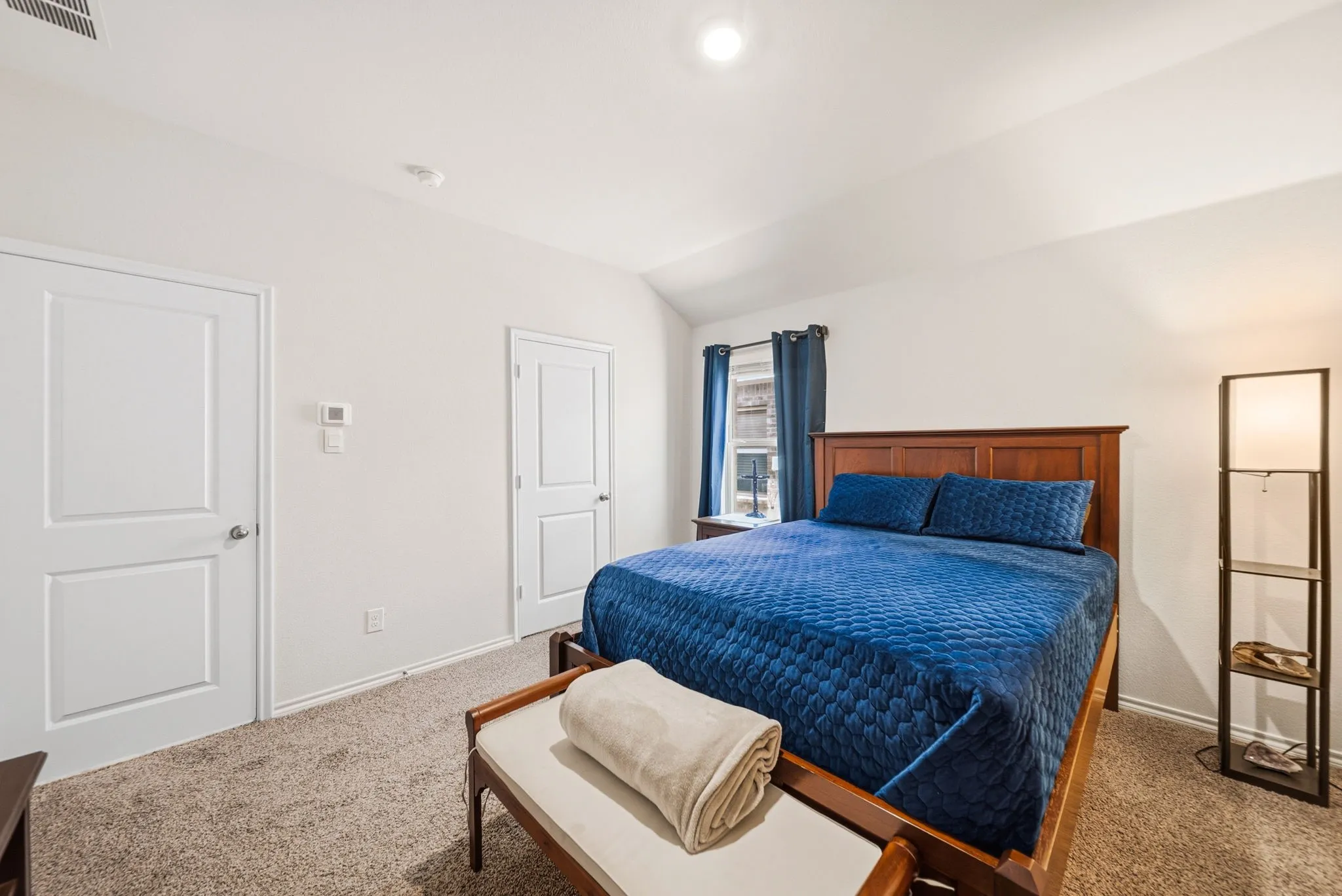 Carpeted flooring, vaulted ceiling, and white panel doors
