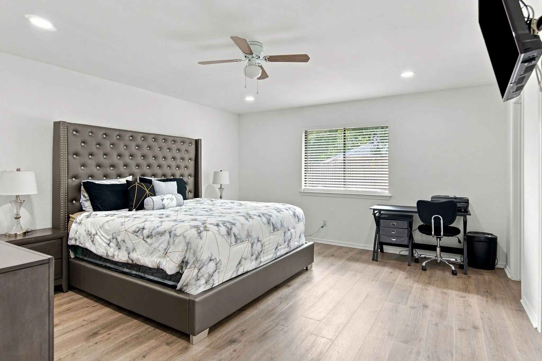 Spacious room featuring wood-finish flooring, recessed lighting, and a ceiling fan