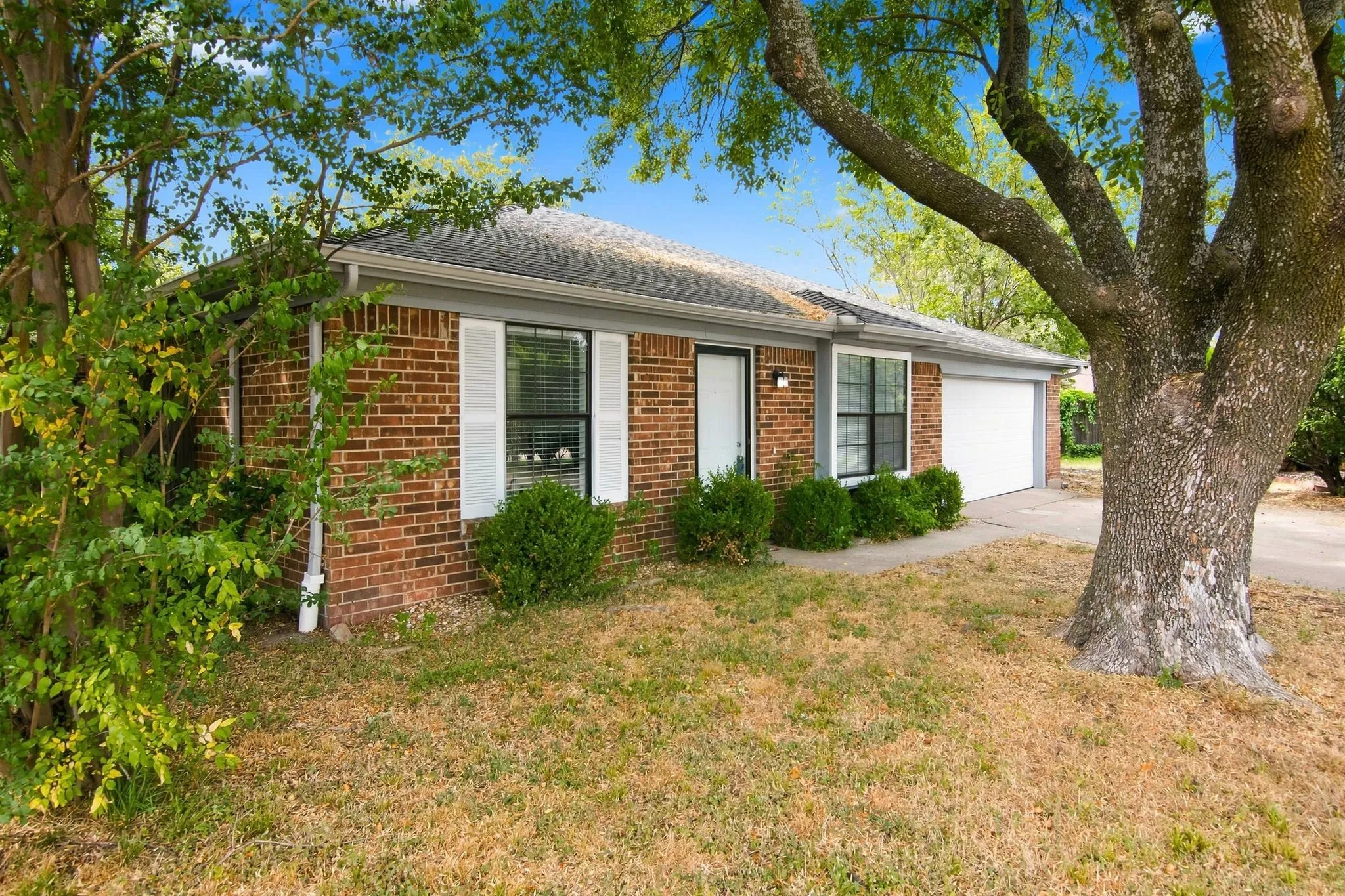 Brick exterior with white shutters and a single-car garage