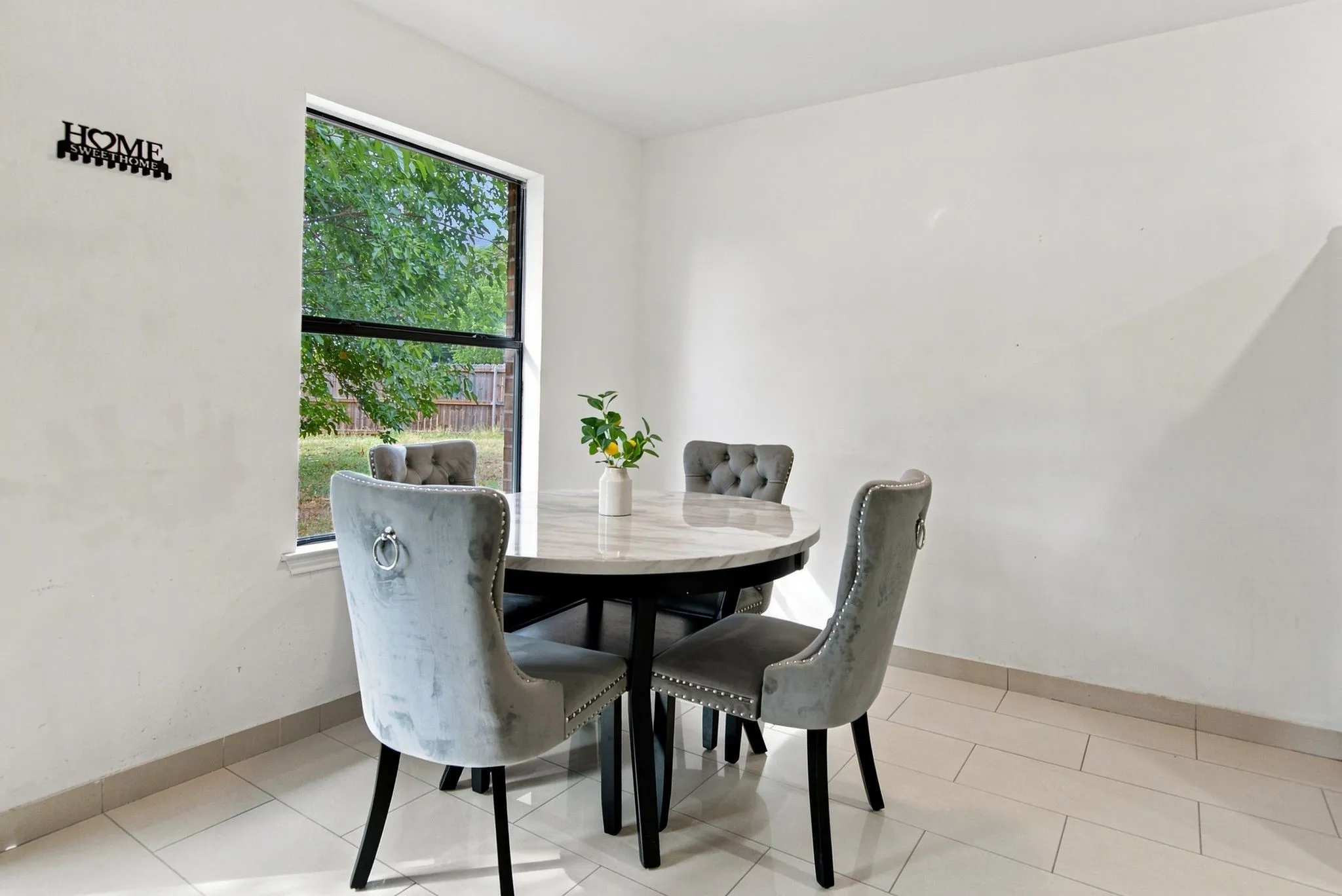 White walls, tiled flooring, and a large window