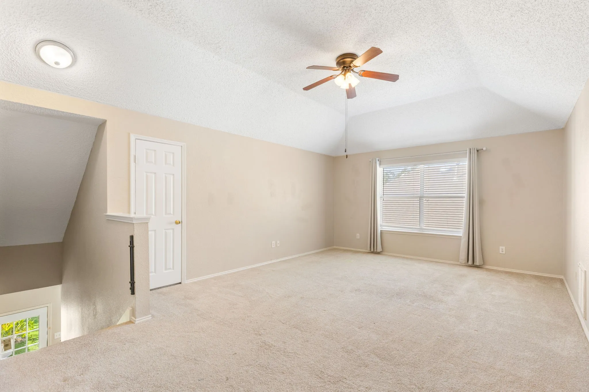 Vaulted ceiling with a ceiling fan, carpeted flooring, and a window with blinds