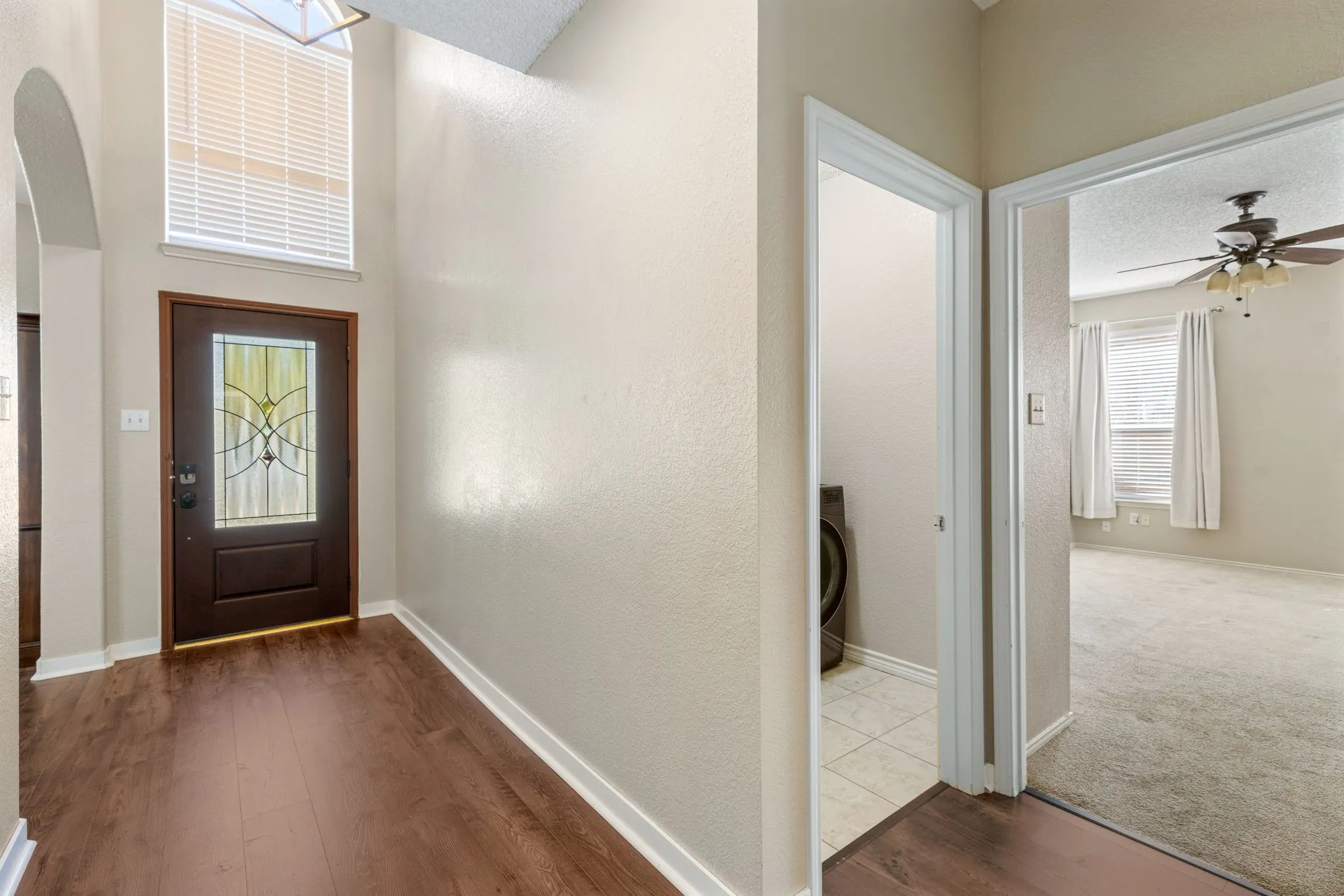 Entryway with wood-finish flooring and a decorative glass-paneled door
