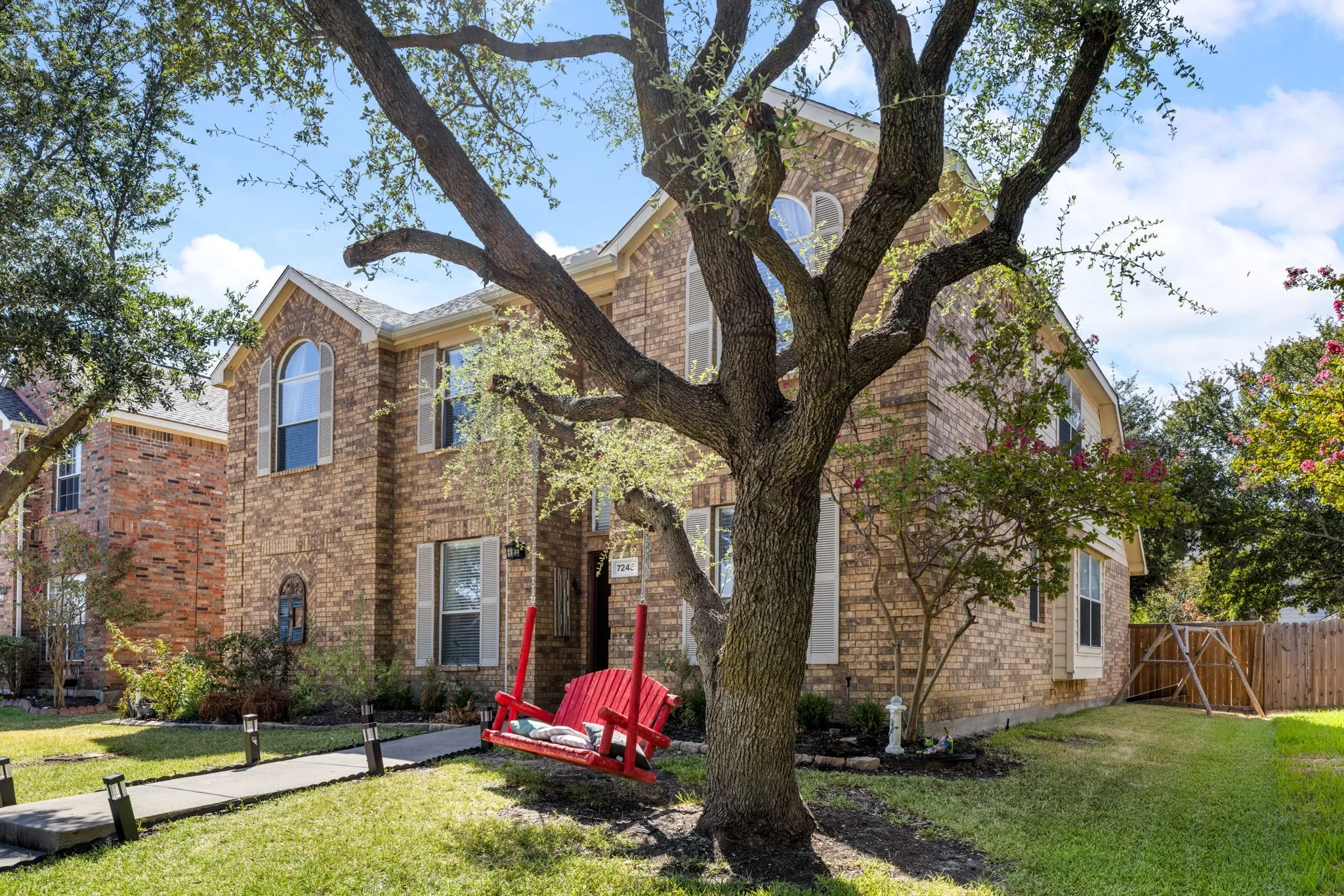 Brick veneer exterior with gabled roofline, arched window, and bay window