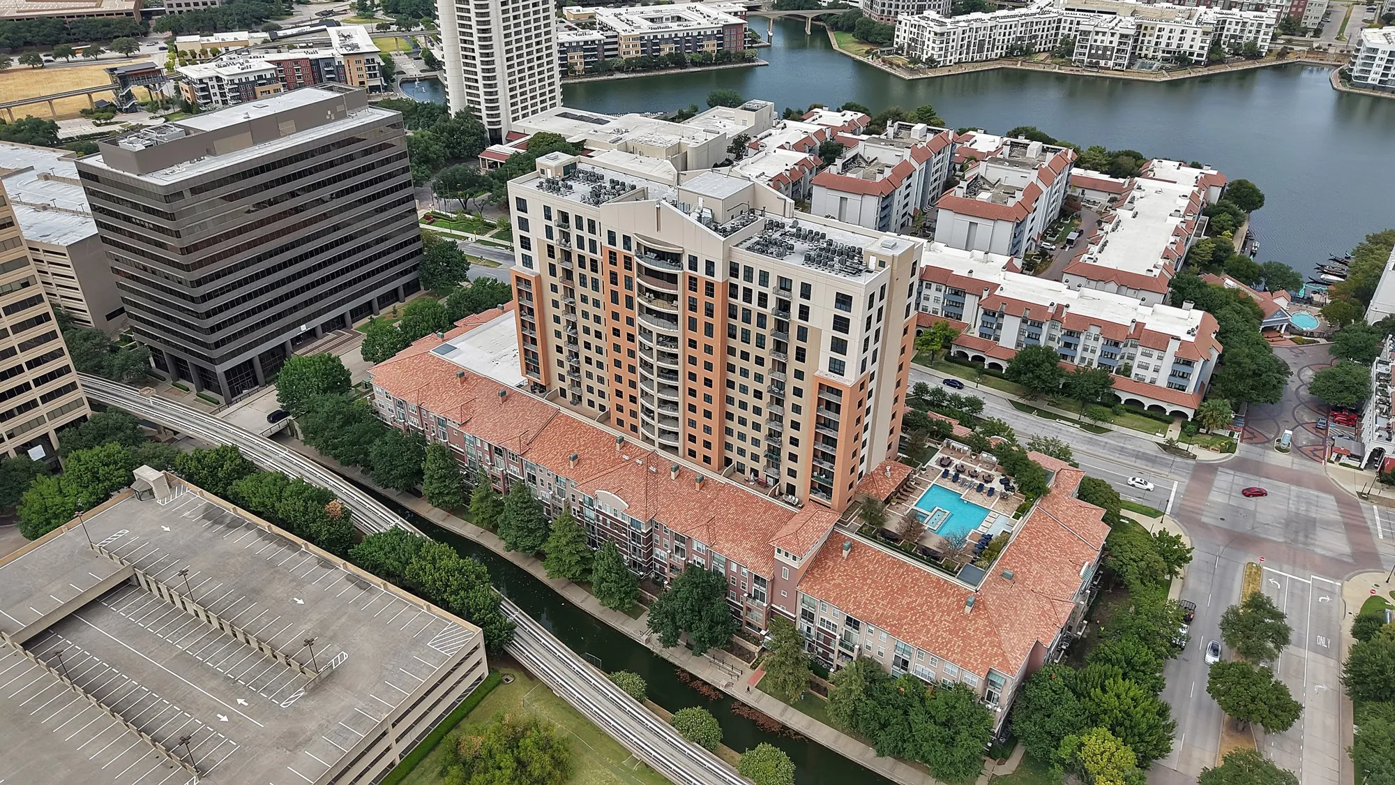 Multi-story residential building with a terraced design, a rooftop swimming pool, and immediate water access