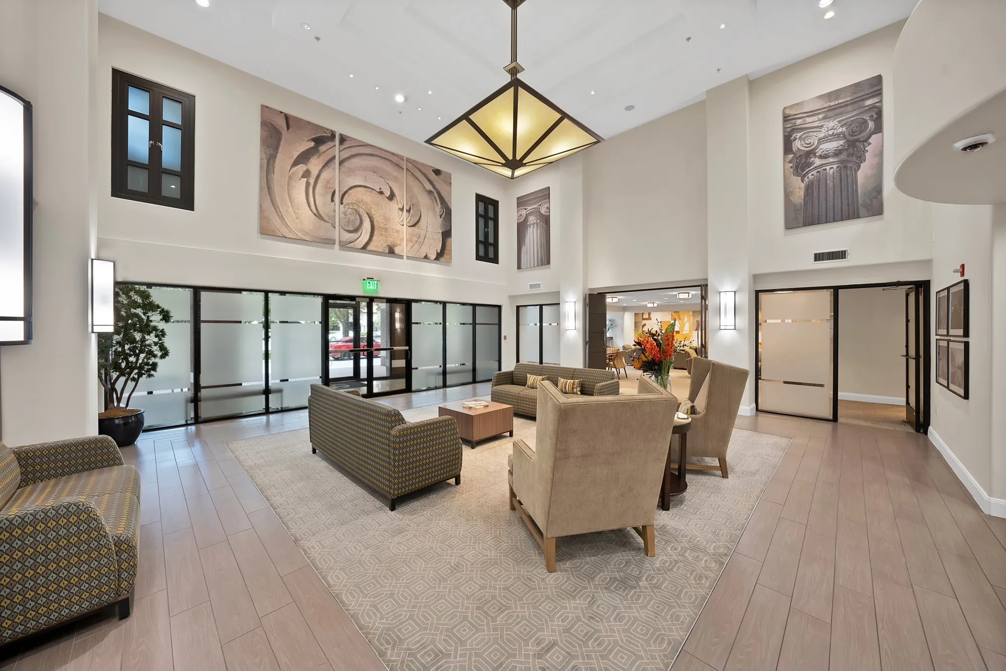 High ceilings with recessed lighting, wood-finish flooring, and a central chandelier
