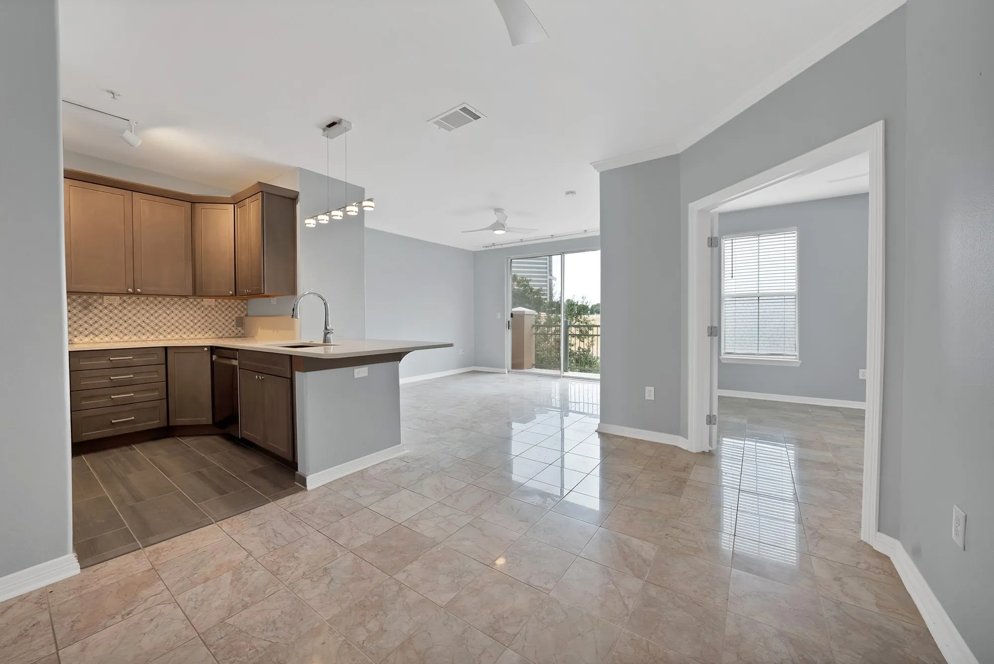 Kitchen with wood-finish cabinetry, tile backsplash, and a breakfast bar