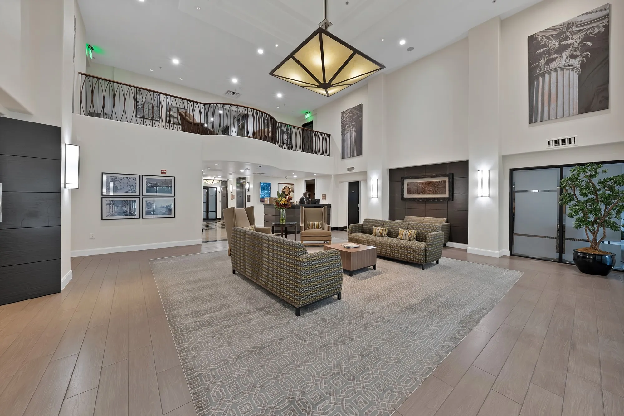 Two-story foyer with high ceilings, wood-finish flooring, and a decorative wrought-iron balcony