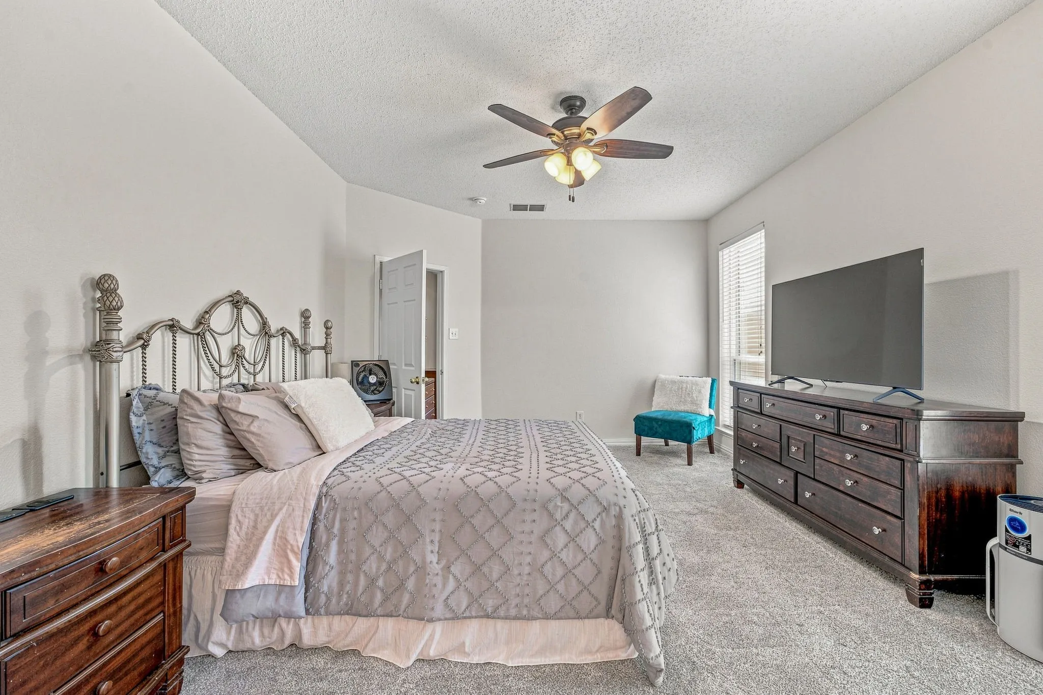 Carpeted room with vaulted ceiling and ceiling fan with integrated lighting