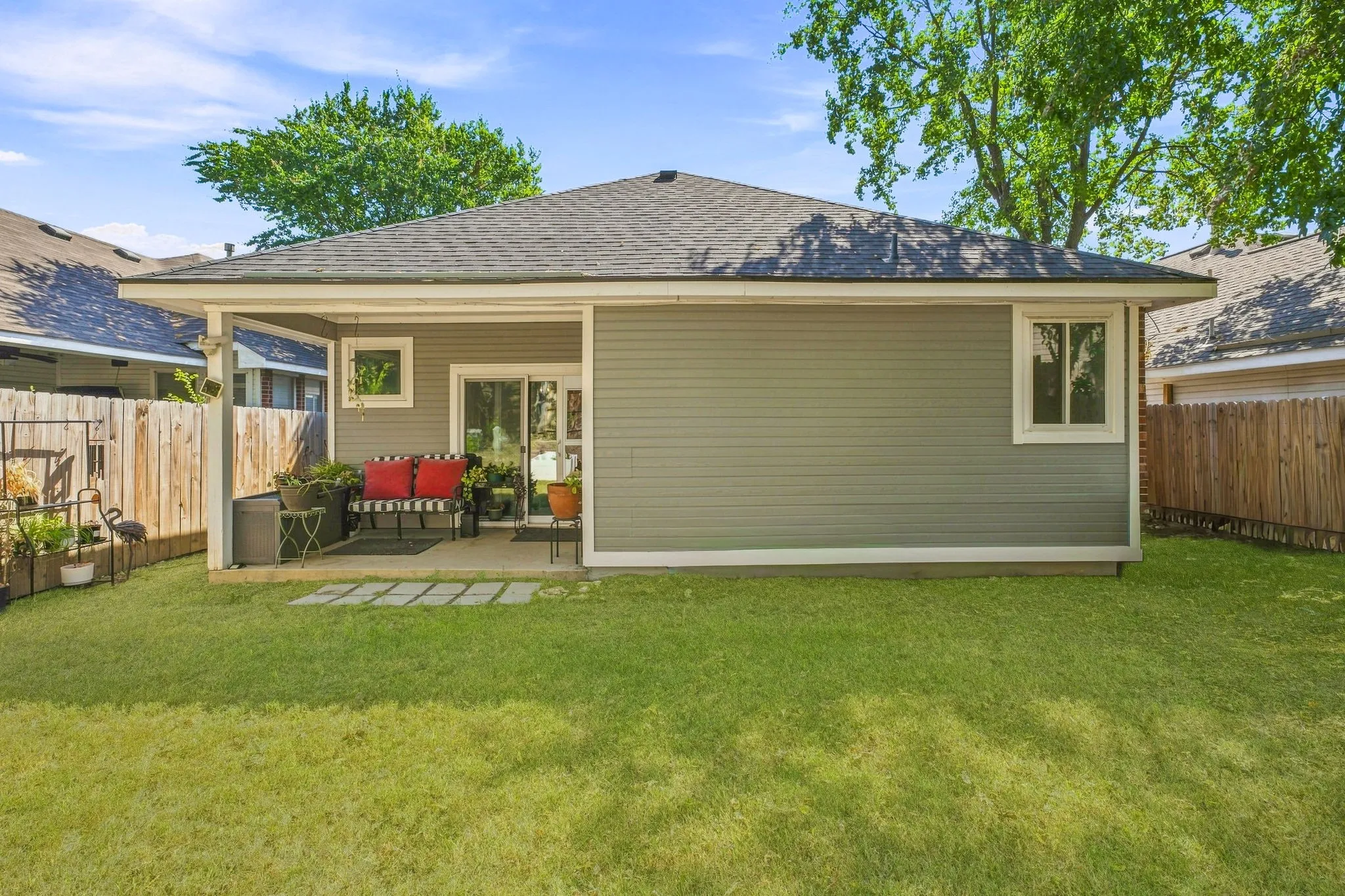 Private rear yard with a covered patio, sliding glass doors, and a partial privacy fence