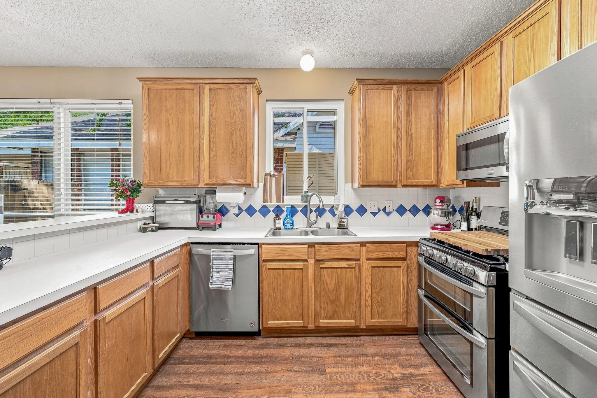 Kitchen featuring wood-finish cabinetry, white countertops, stainless steel appliances, and wood-finish flooring