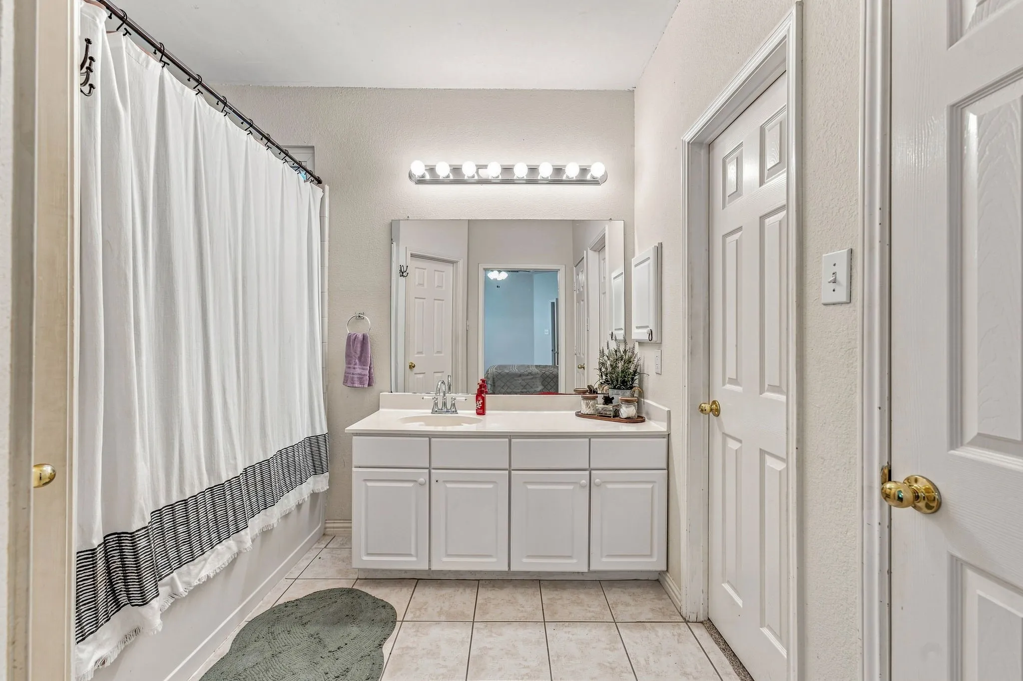 Single vanity with ample counter space, built-in cabinetry, and overhead lighting