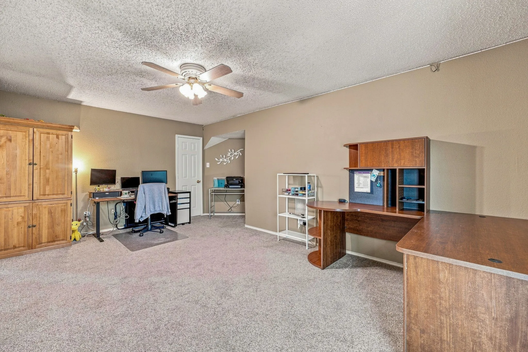 Carpeted room featuring neutral wall tones and a ceiling fan