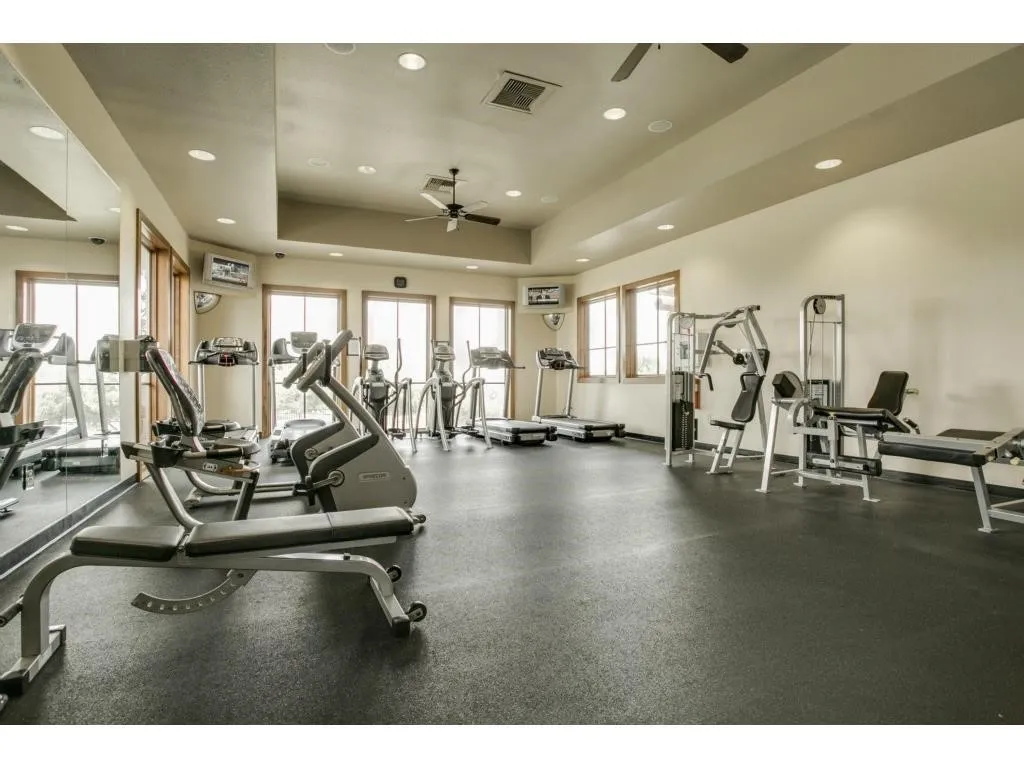 Fitness room with rubber flooring, recessed lighting, and multiple windows