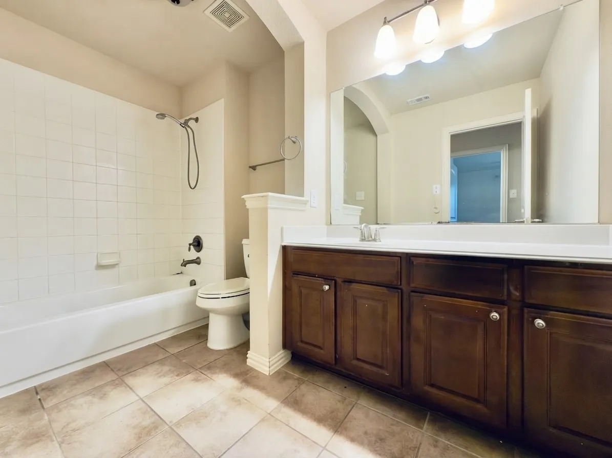 Spacious vanity with wood-finish cabinetry and a white countertop