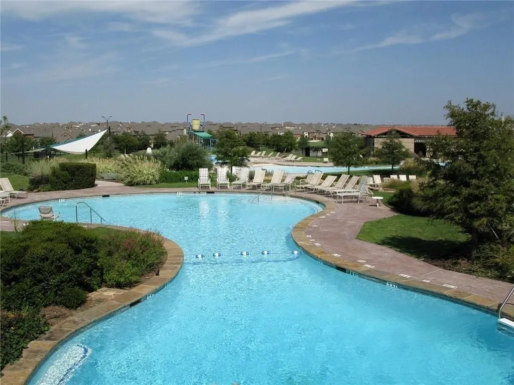 Community swimming pool with a meandering design and stone coping
