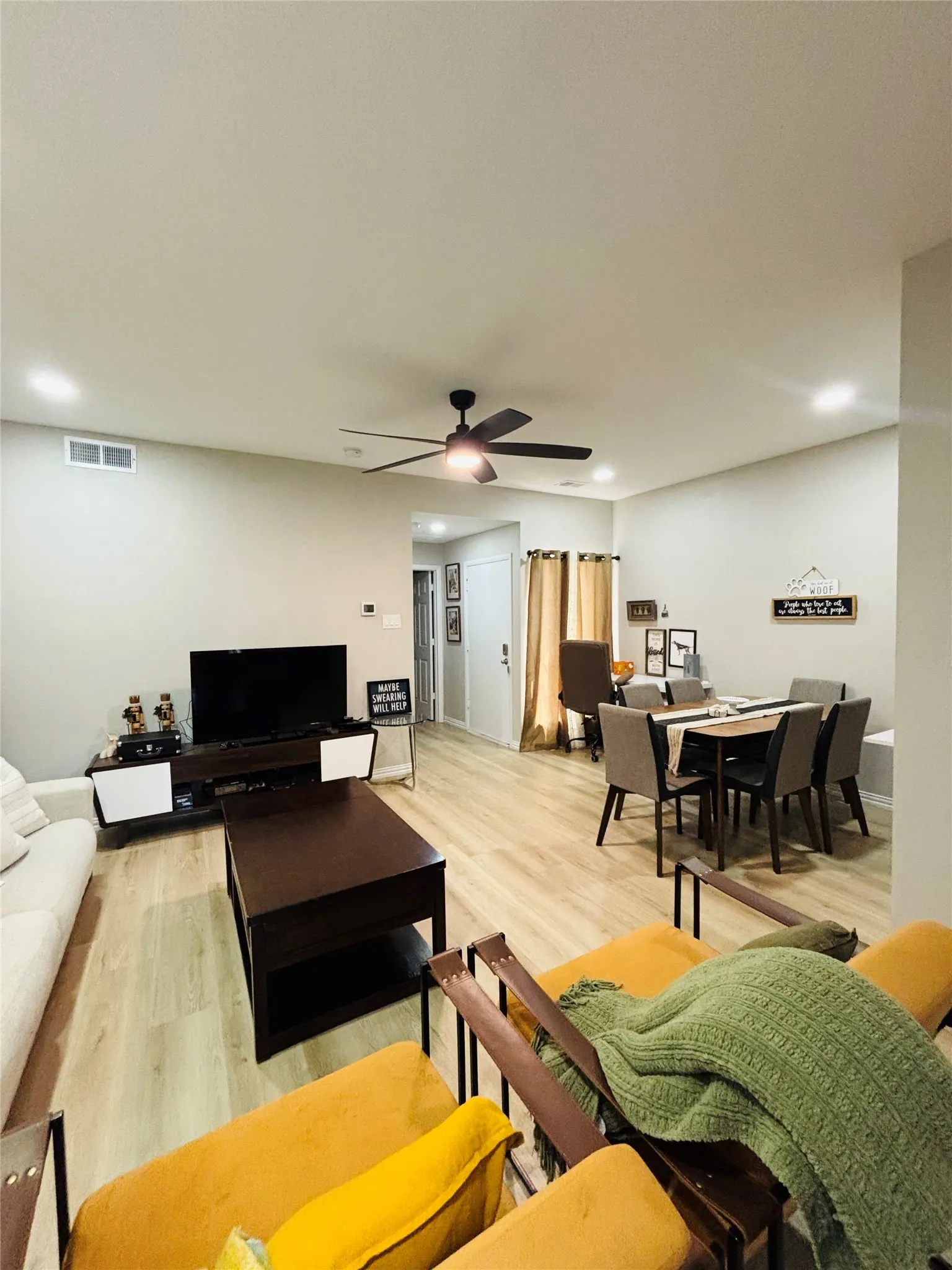 Open-concept living area featuring wood-finish flooring, recessed lighting, and a ceiling fan
