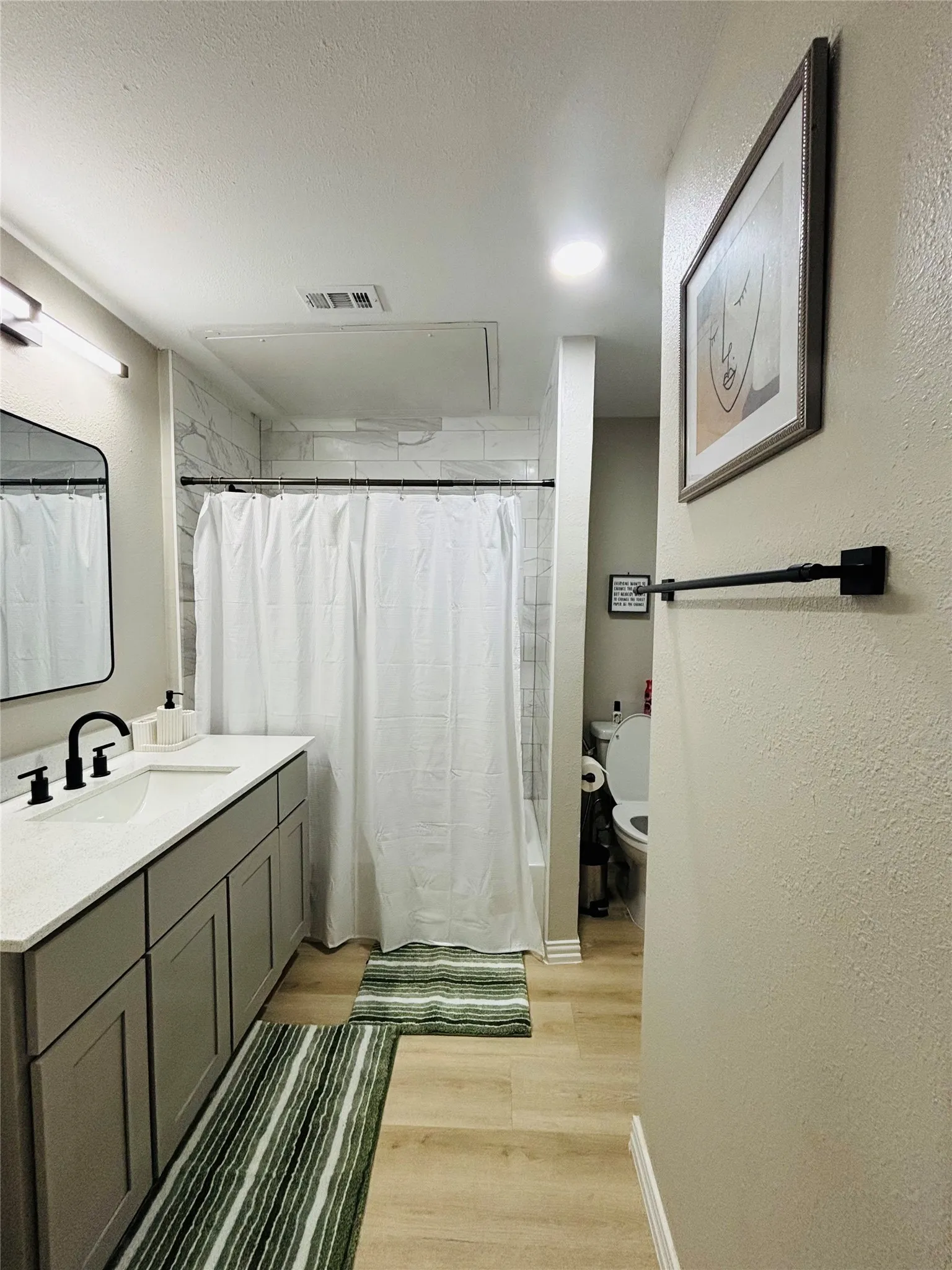 Vanity with gray cabinetry, white countertop, and black fixtures