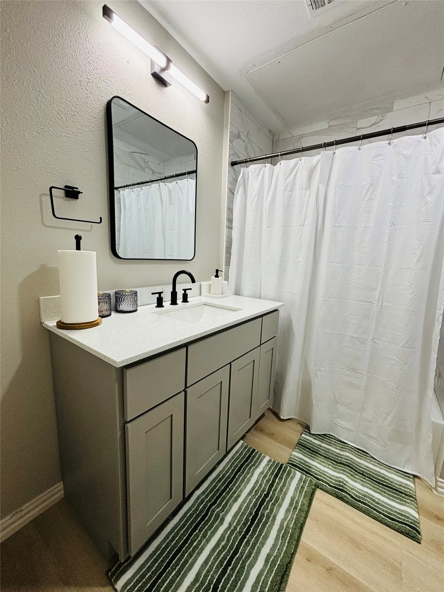 Vanity with a light-colored countertop, undermount sink, and matte black faucet