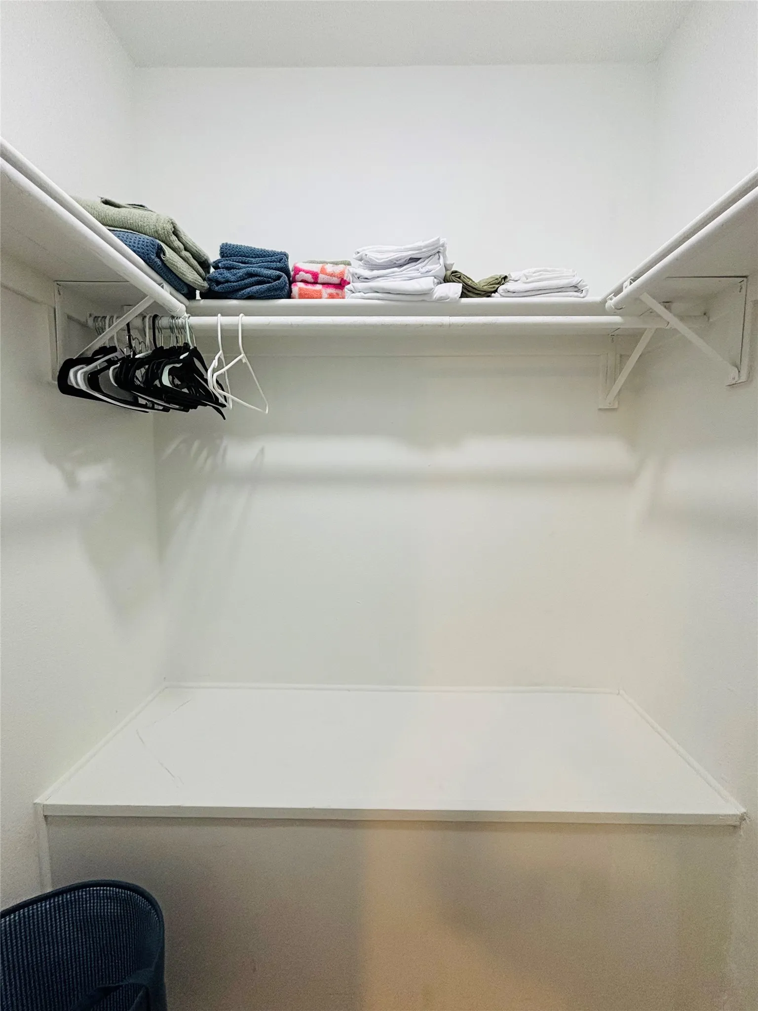 Built-in closet system featuring white shelving and hanging rods