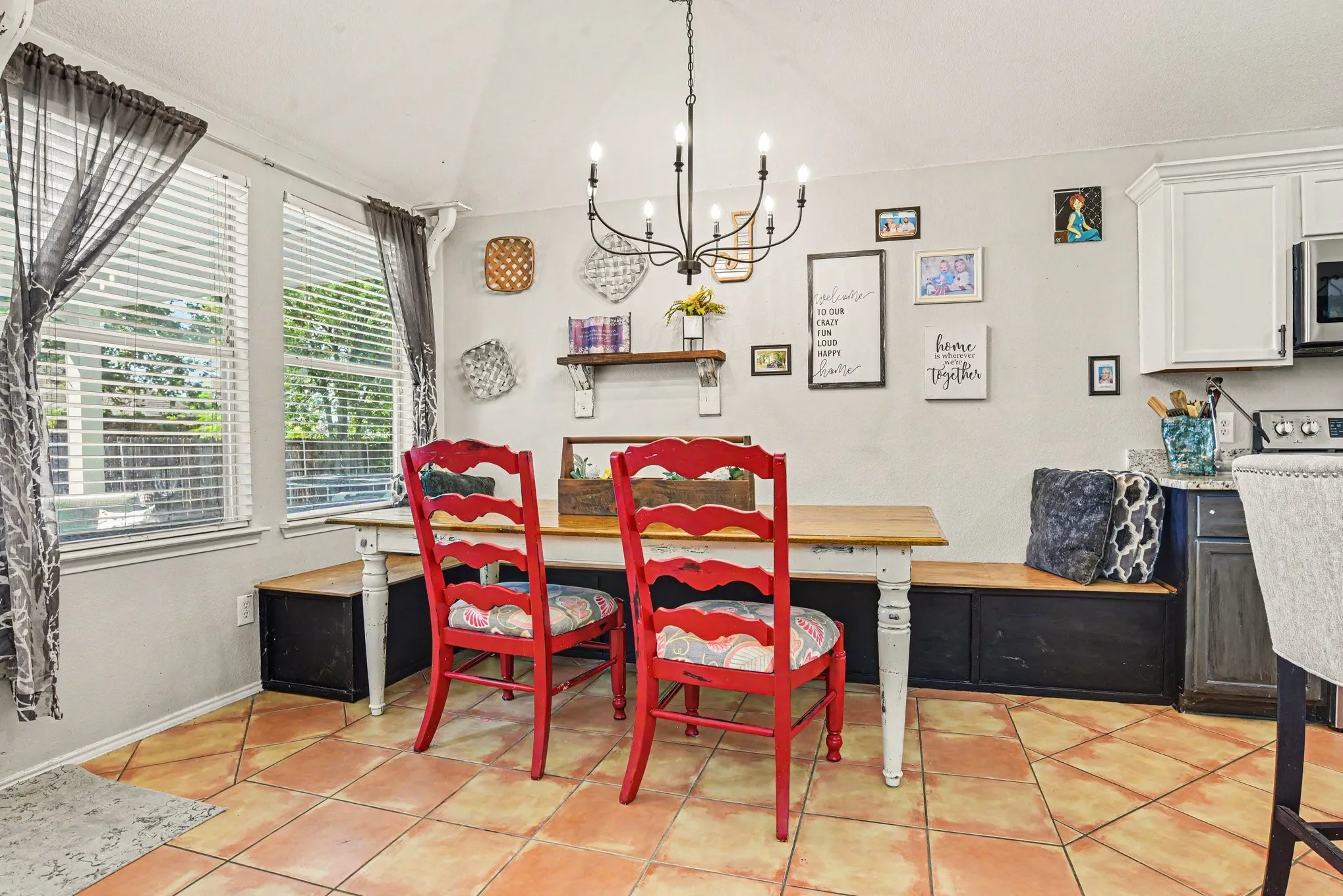  overhead chandelier, two large windows, built-in bench seating, tile flooring, and white cabinetry