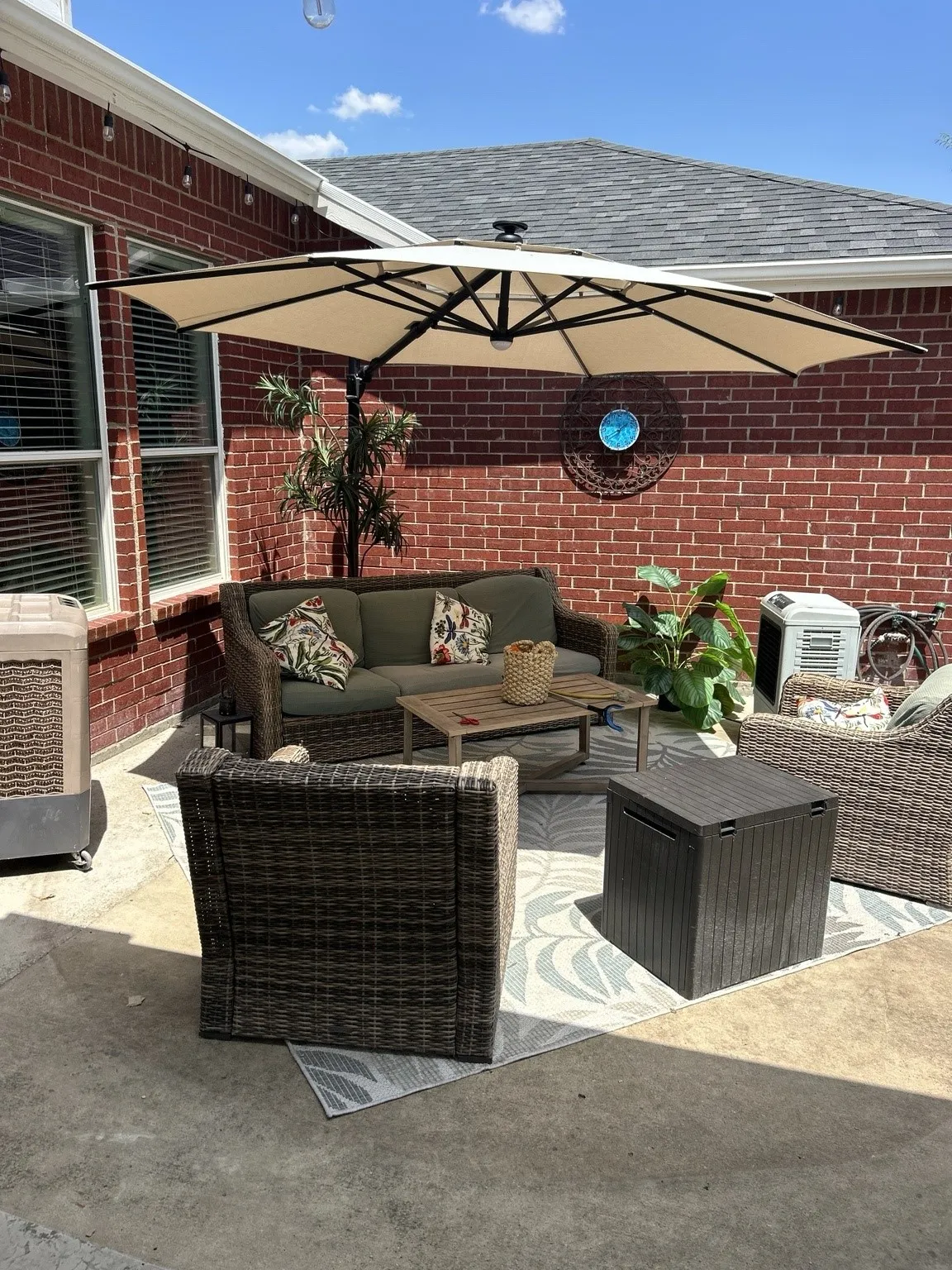 Private patio space featuring a red brick exterior, concrete flooring, and a shaded area