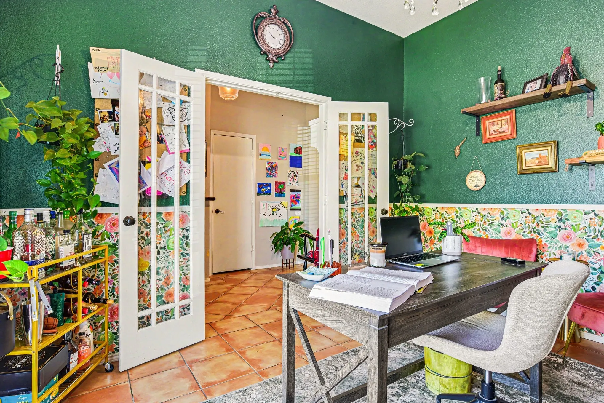 Double French doors with multiple glass panes open to a room featuring tile flooring, painted walls, and built-in shelving