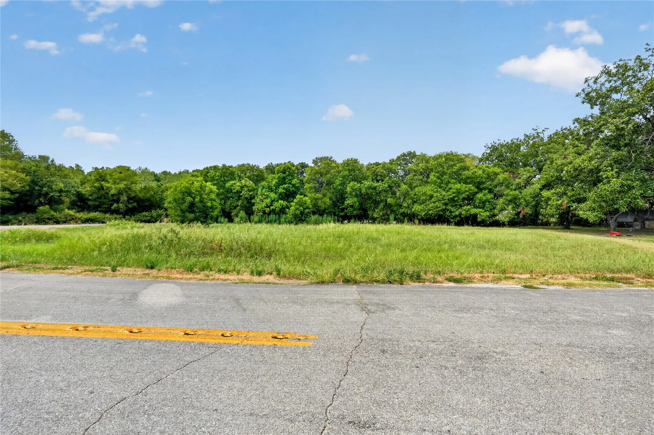 Expansive, undeveloped lot with a natural grass surface