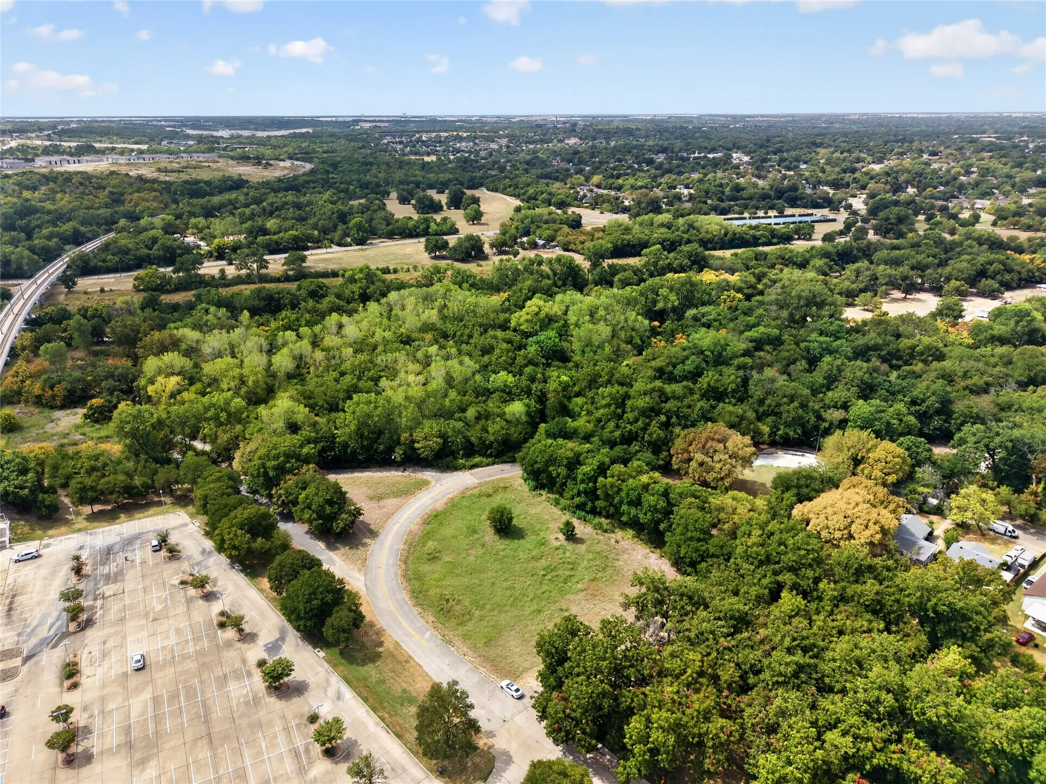 Extensive wooded landscape with a curved paved road