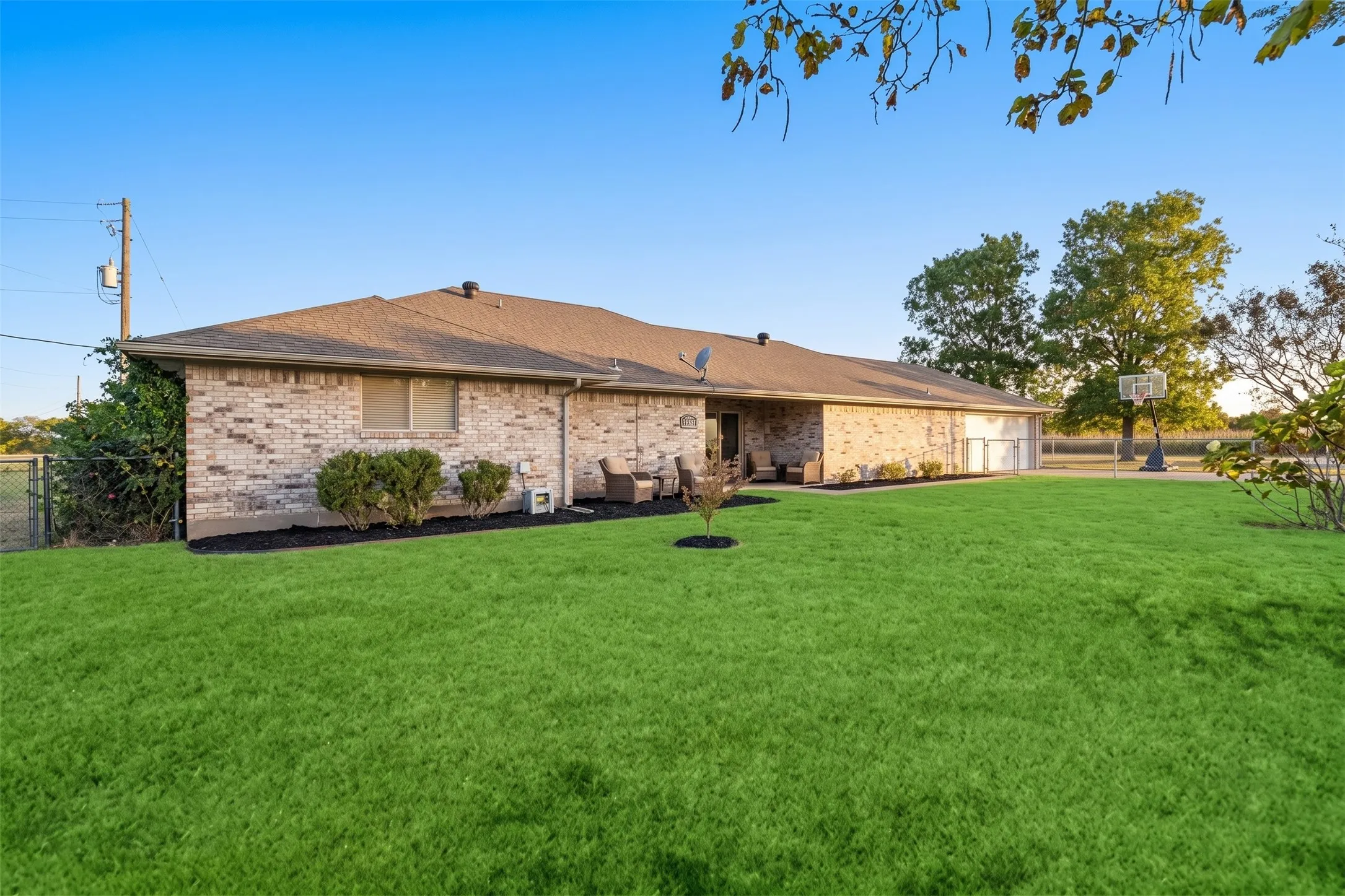 Brick-clad exterior with a pitched roof, surrounded by a expansive lawn and mature landscaping