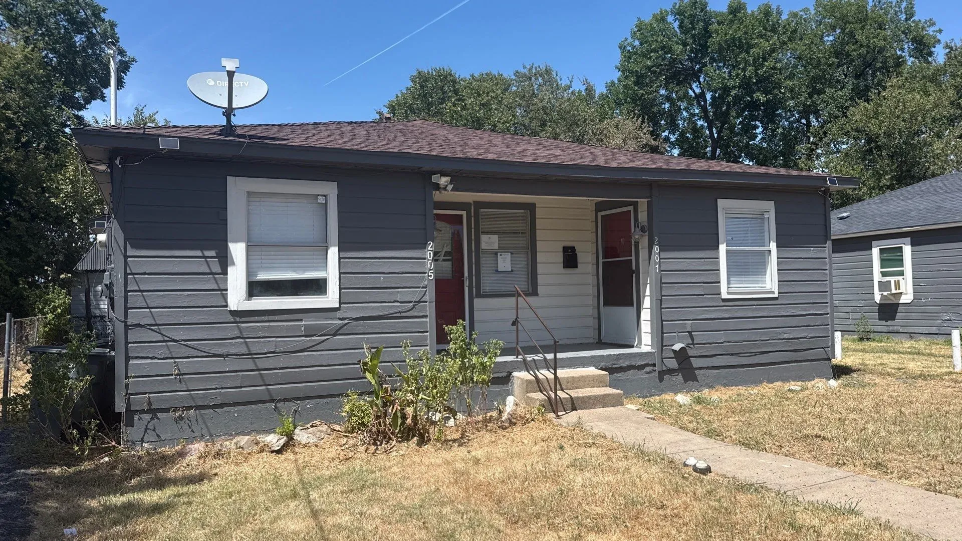 Gray horizontal siding exterior with white window trim and a brown shingled roof