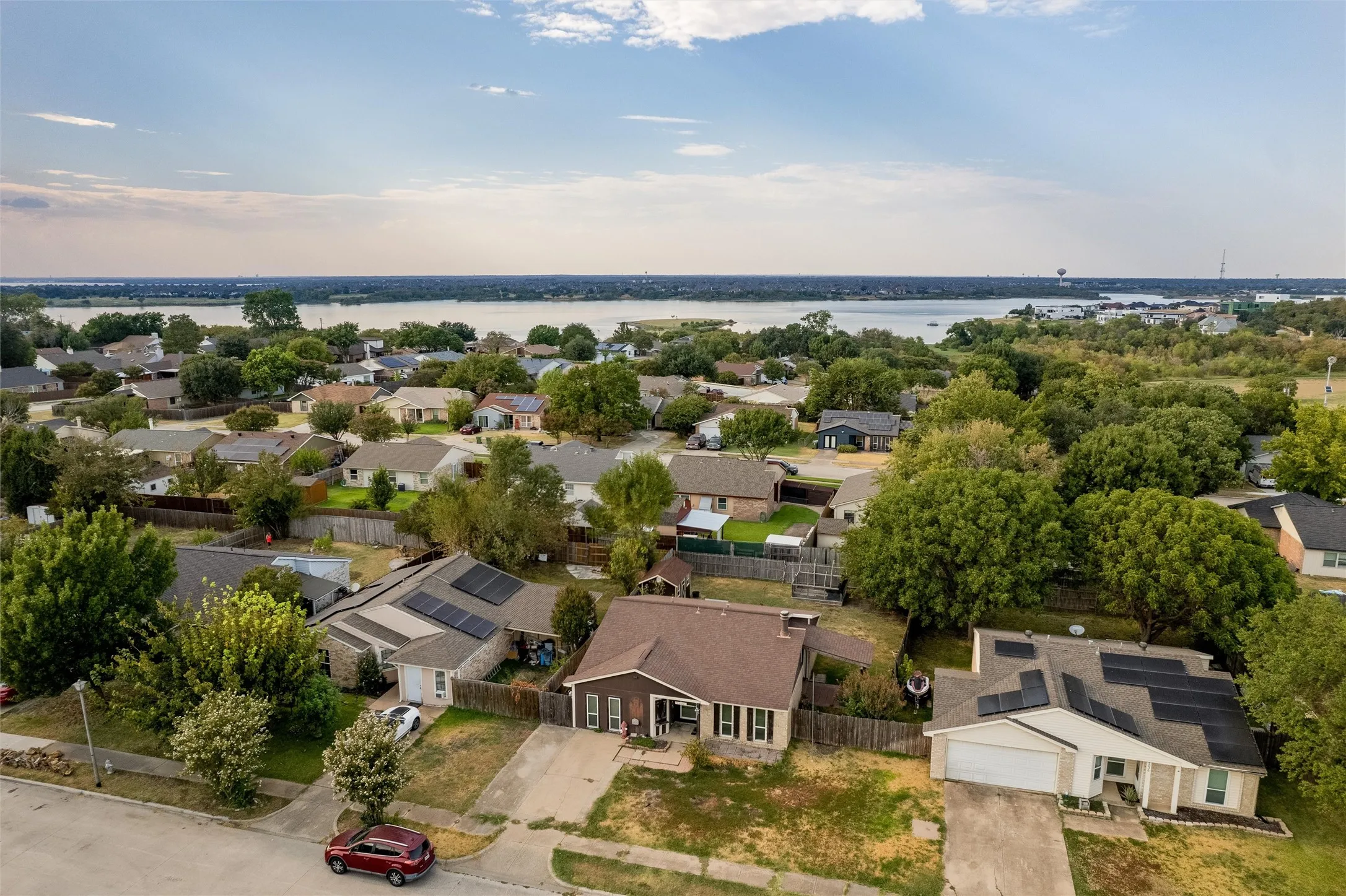 Residential neighborhood with mature trees and a distant body of water