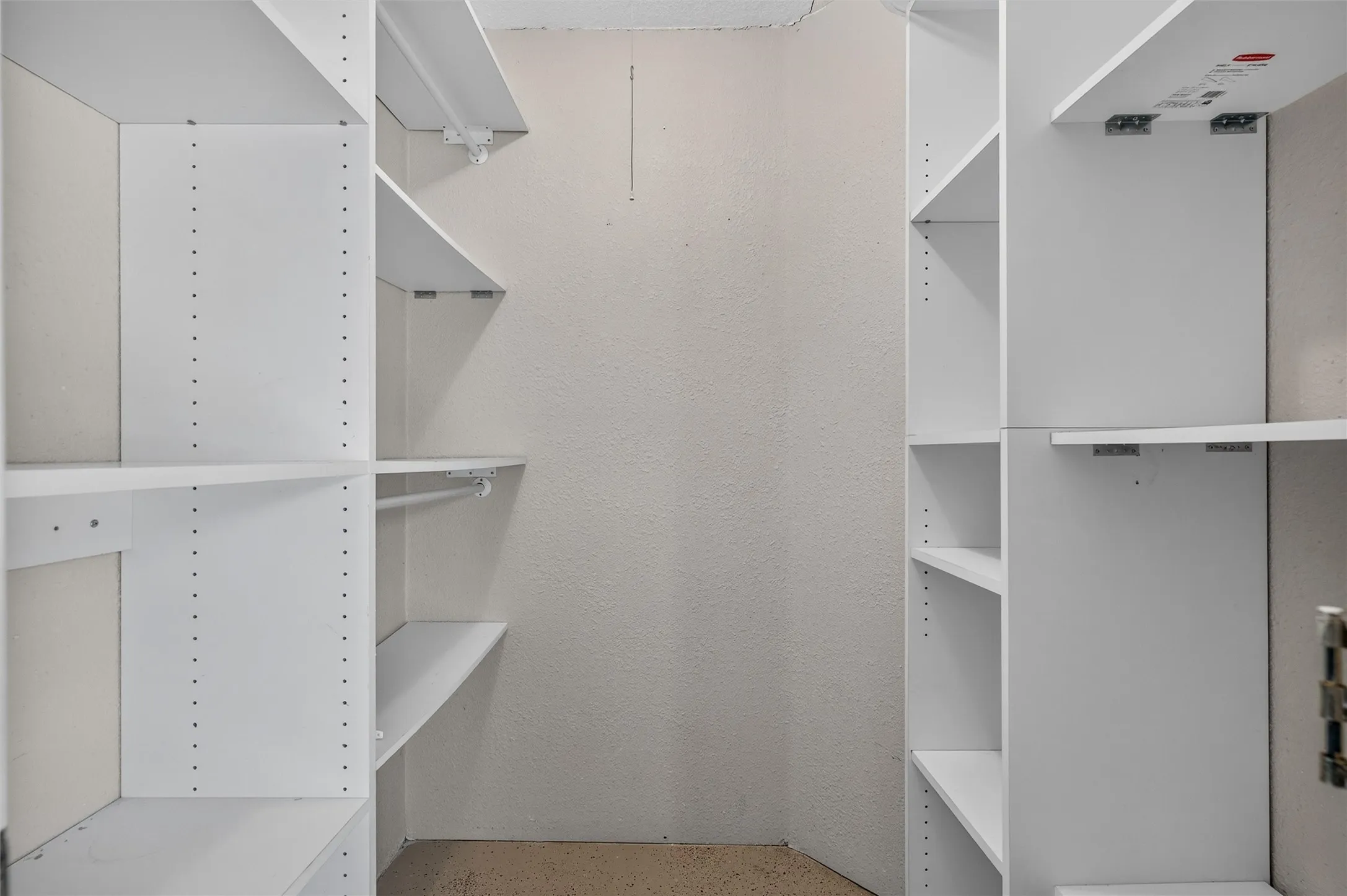 Built-in white storage shelving, adjustable shelves, and garment hanging rod