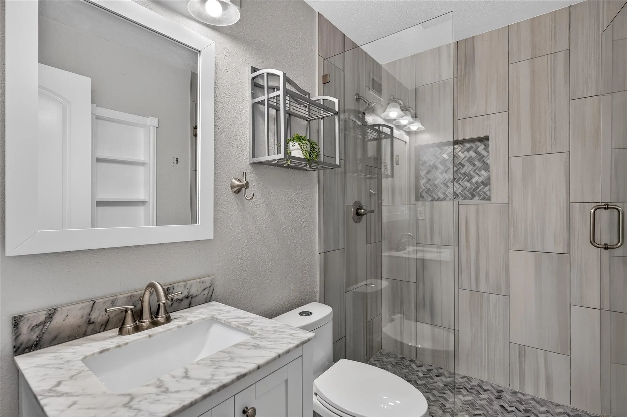 Vanity with a marble-finish countertop, undermount sink, and brushed nickel faucet