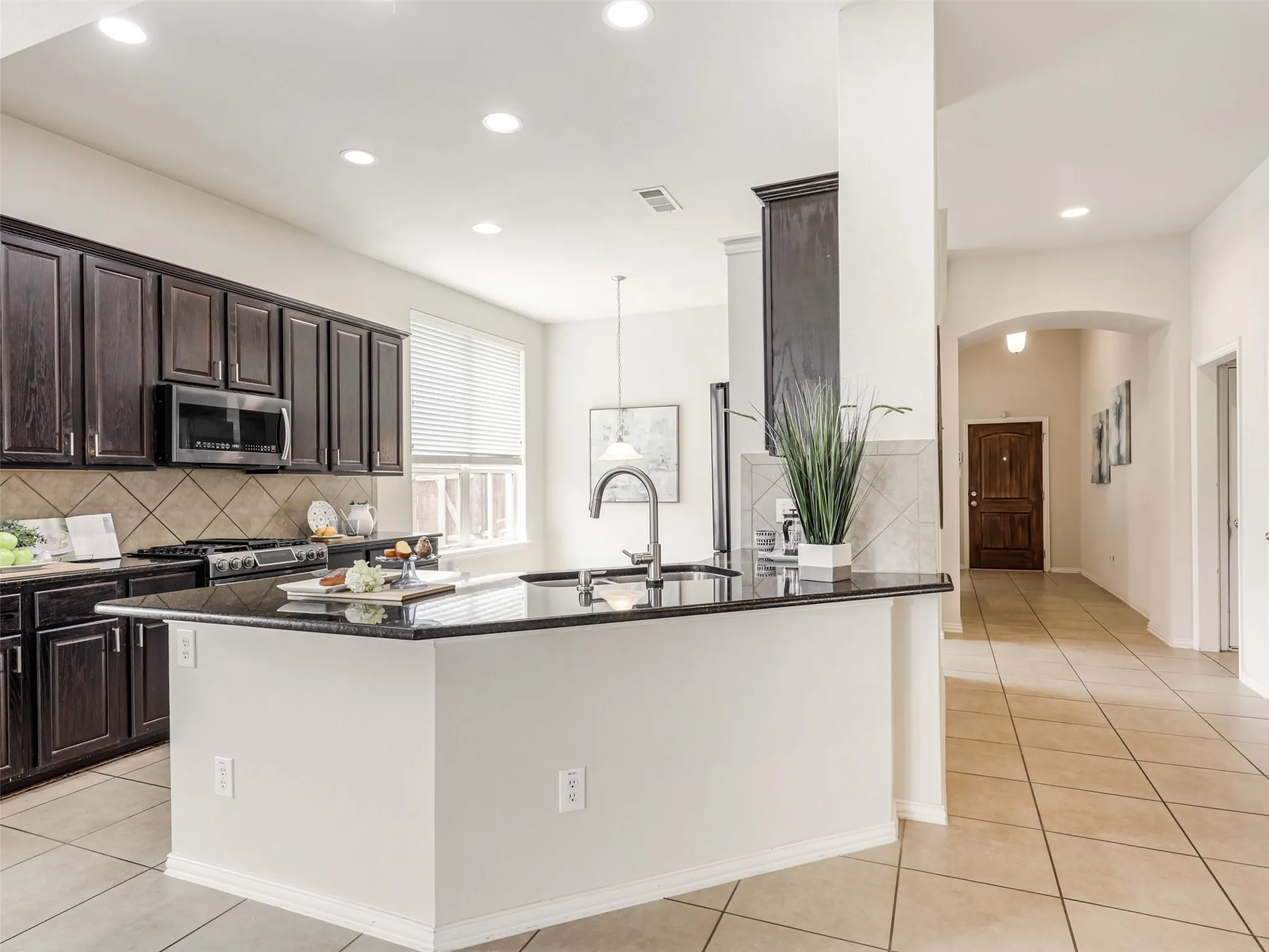 Expansive breakfast bar offers additional prep space and casual seating while connecting the kitchen to the surrounding living areas.