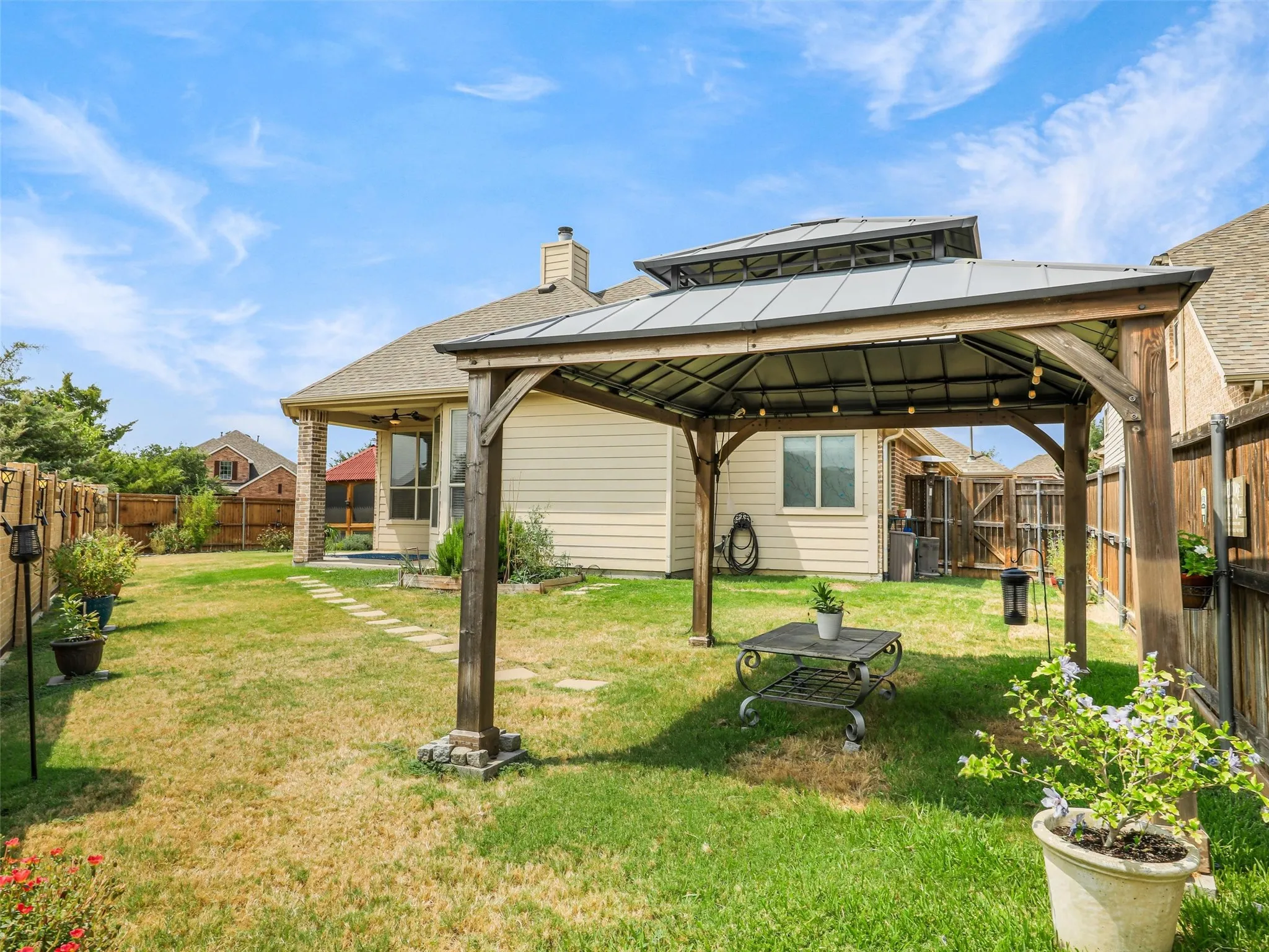 Backyard gazebo provides a shaded gathering space ideal for outdoor dining, entertaining, or simply unwinding.