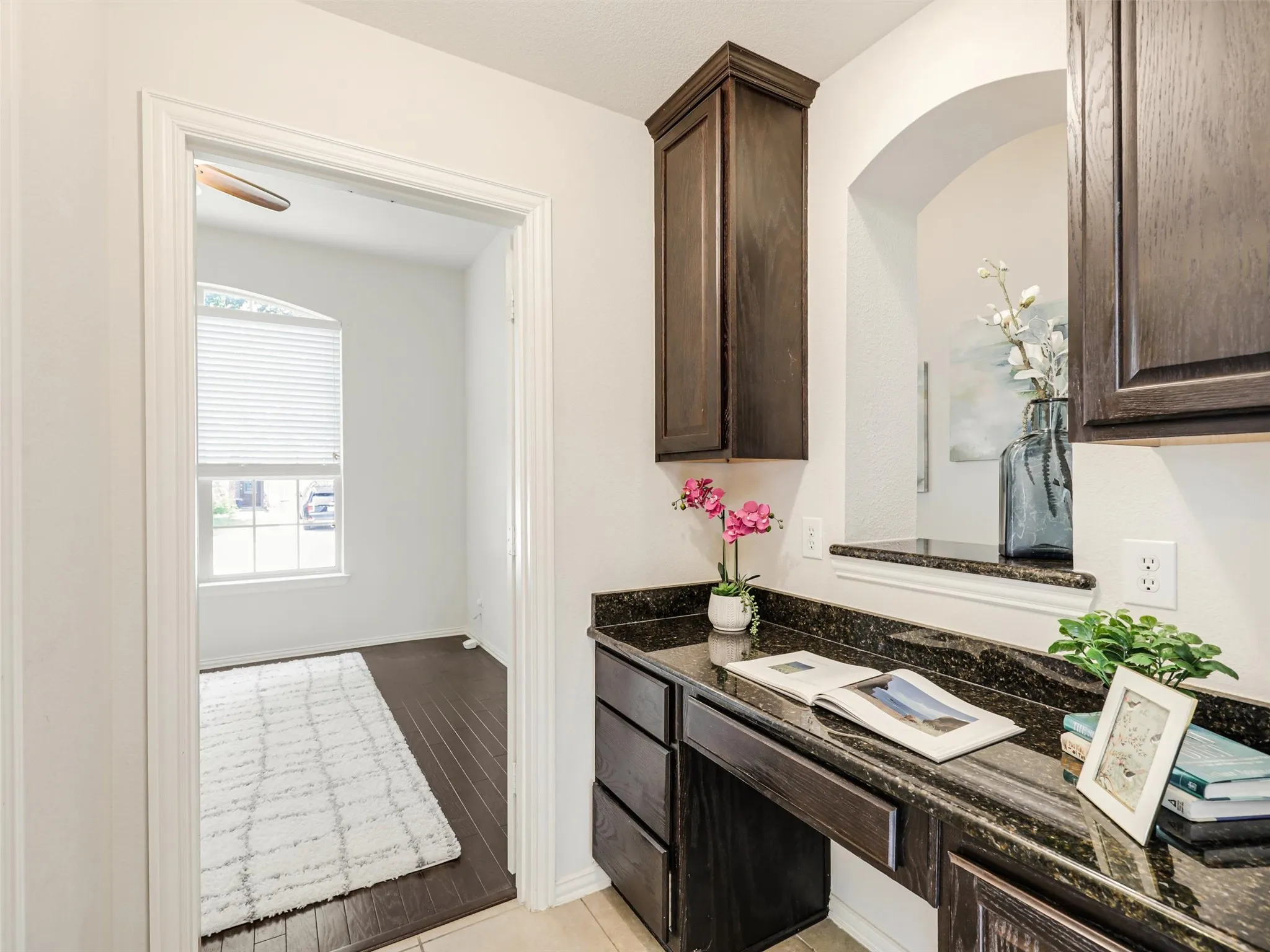 Functional built-in workspace with rich cabinetry, granite countertops, and convenient storage—ideal for working or studying from home.