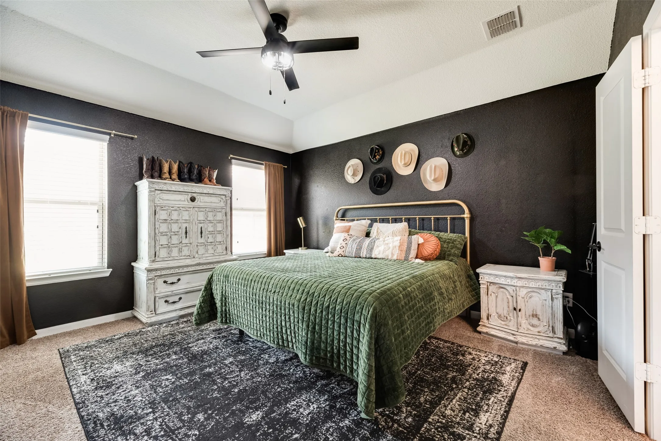 Ceiling fan with integrated lighting, textured wall finish, and two windows with blinds