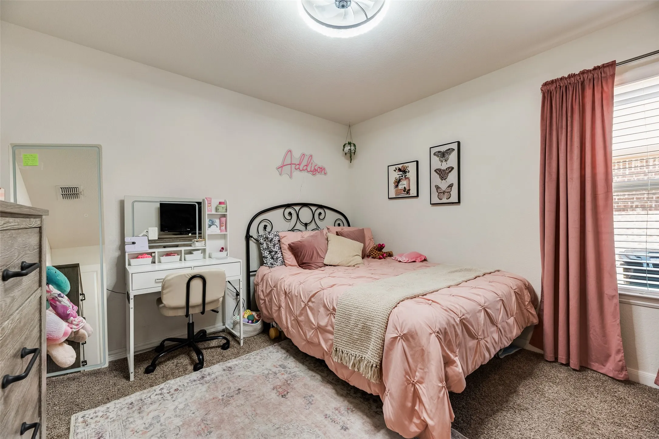 Neutral wall paint, textured carpeting, window with blinds, and ceiling-mounted light fixture