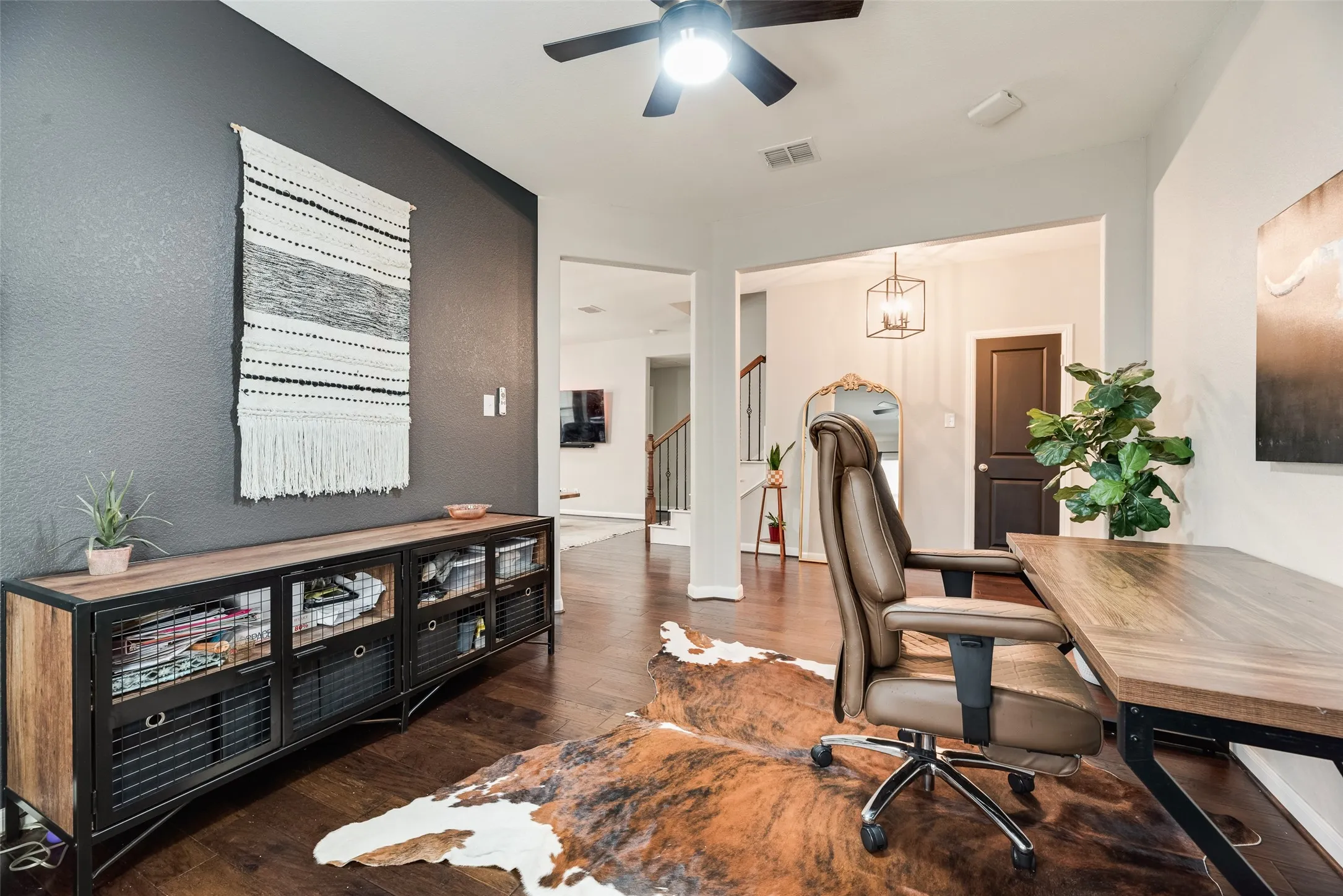 Dark wood-finish flooring, ceiling fan with integrated lighting, recessed lighting, and a contemporary light fixture