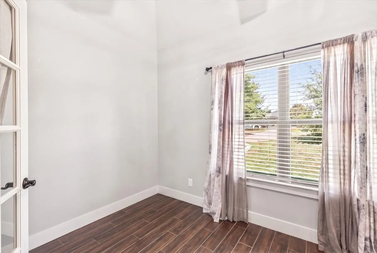 French doors with clear glass panes, wood-finish flooring, and a large window with blinds