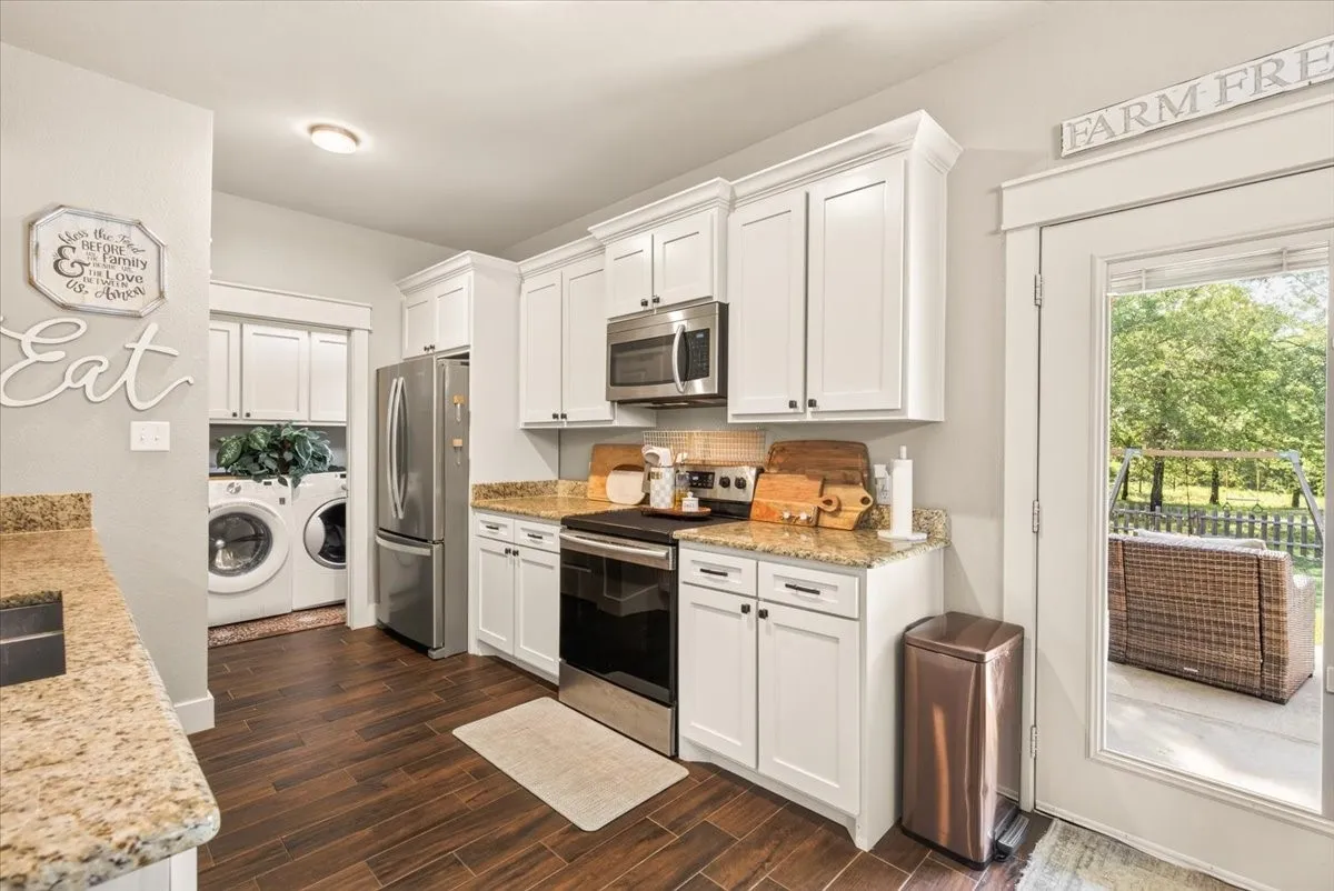 Kitchen with white cabinetry, stainless steel appliances, and a tiled backsplash