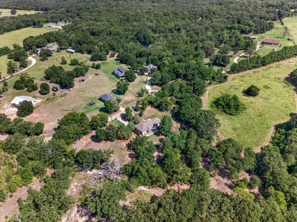 Expansive wooded acreage with a main residence and multiple outbuildings