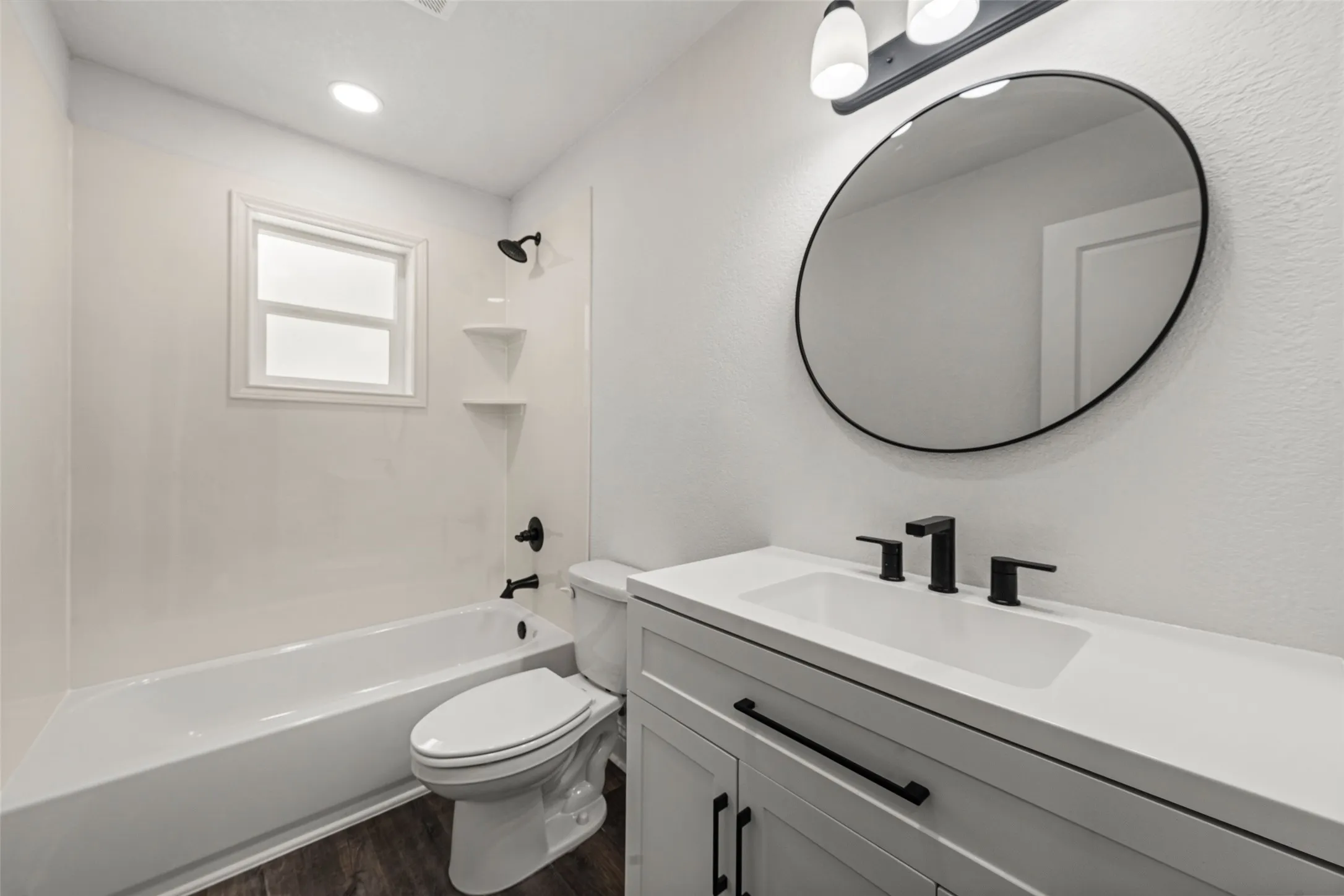 Contemporary bathroom featuring a single white vanity with an integrated sink and matte black fixtures