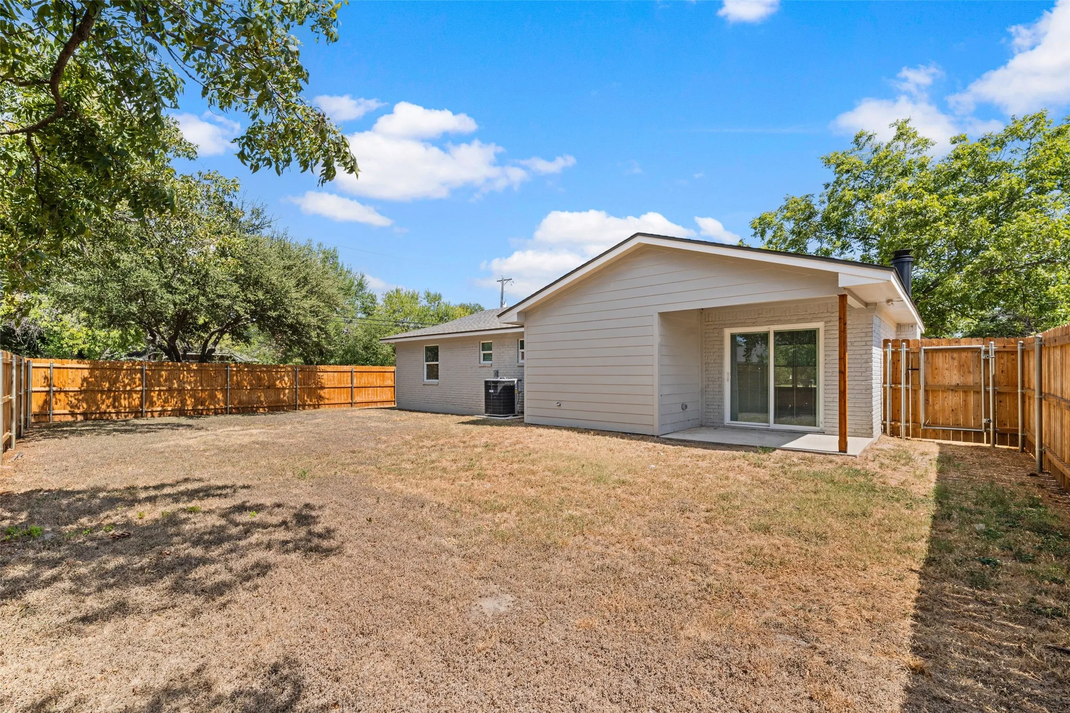 Spacious backyard with mature landscaping and wooden privacy fencing