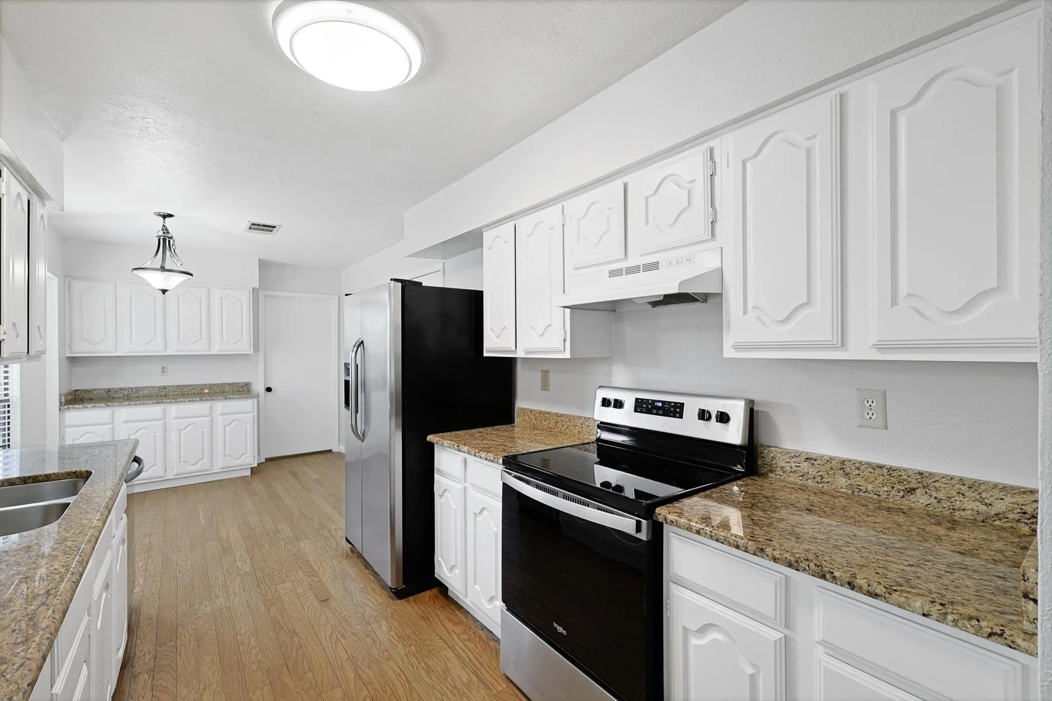 Kitchen with range and refrigerator