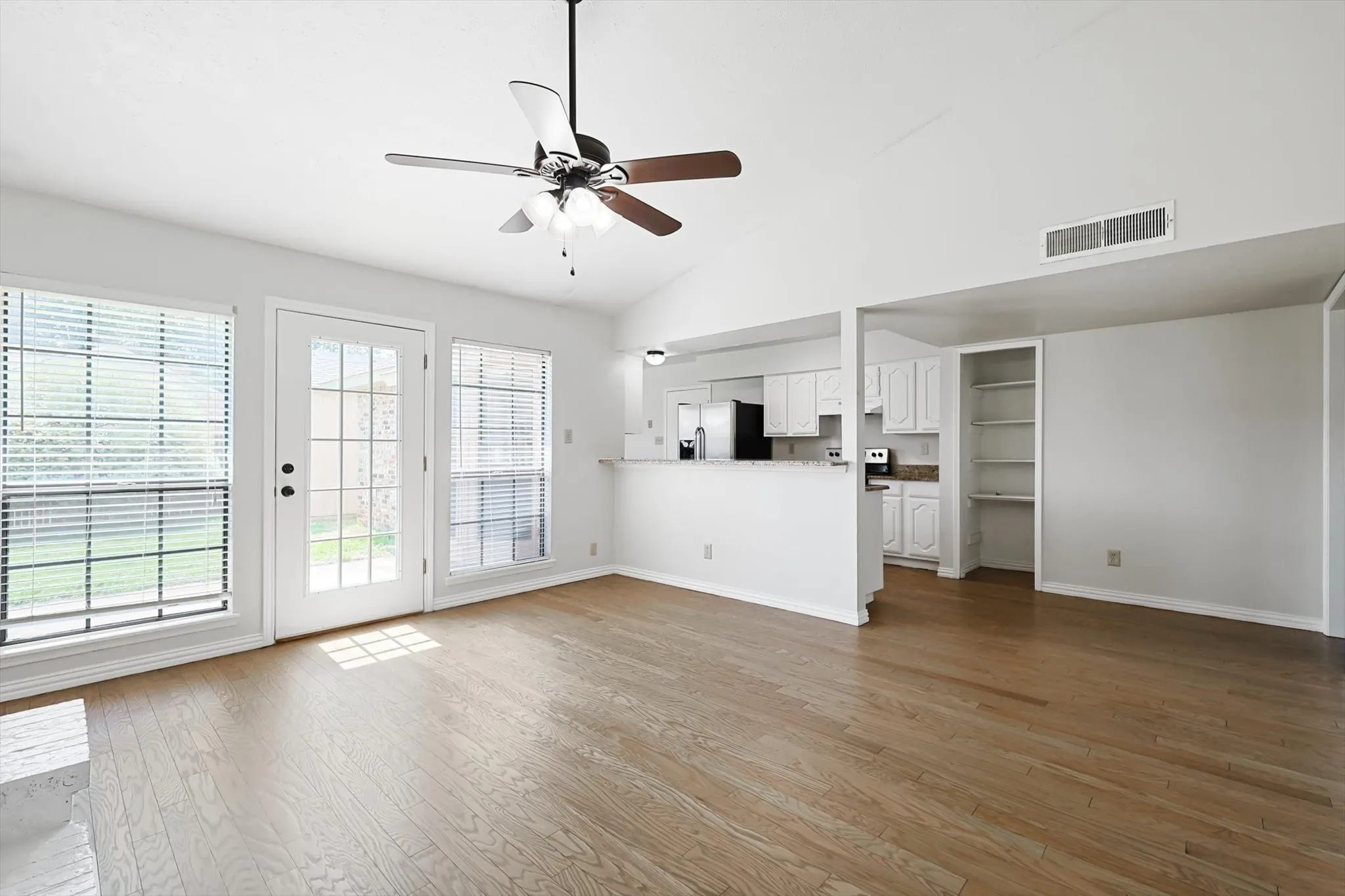 Kitchen with refrigerator, range, pantry open to family room with fireplace
