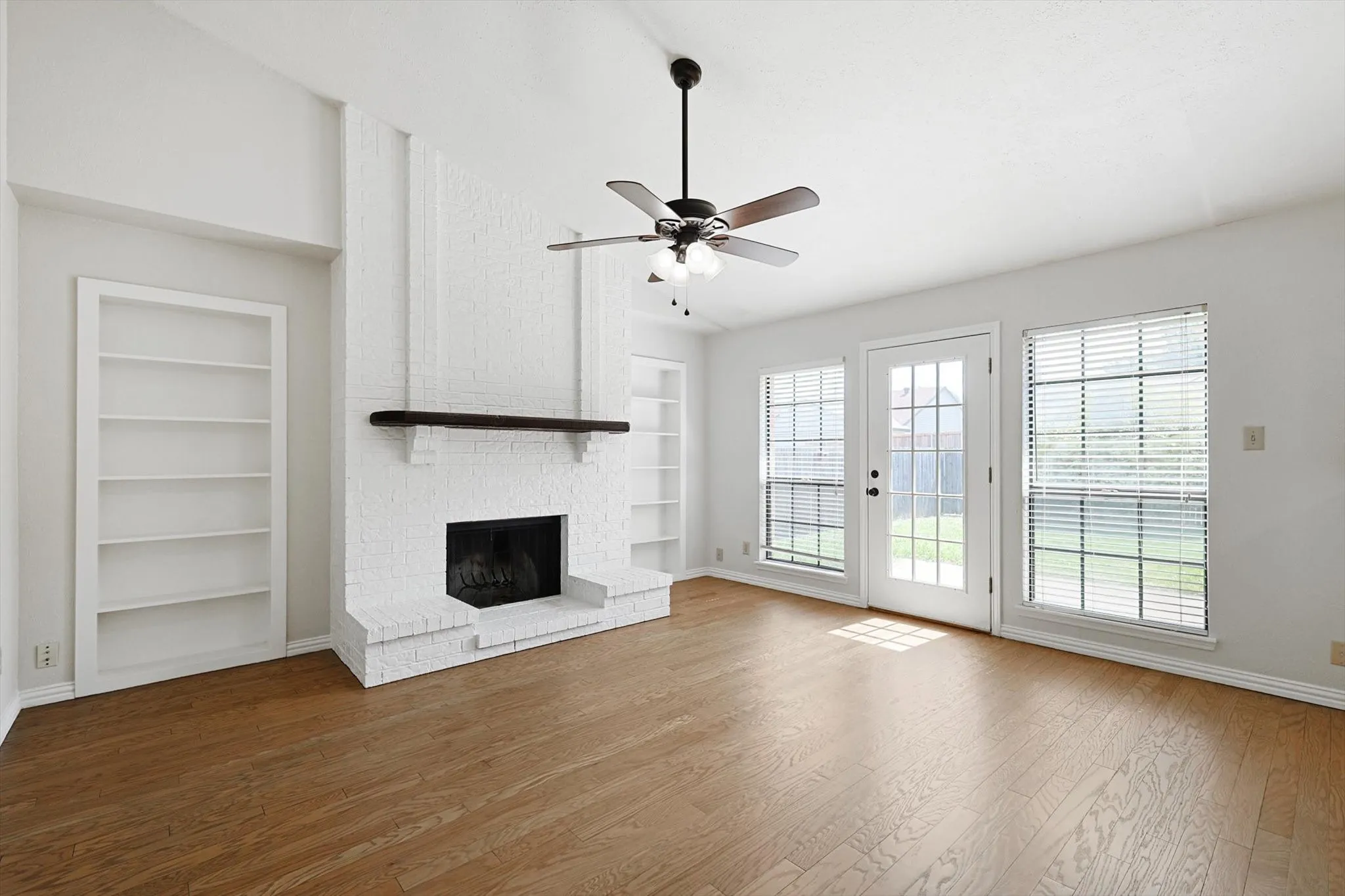 Fireplace, ceiling fan and an abundance of natural light.