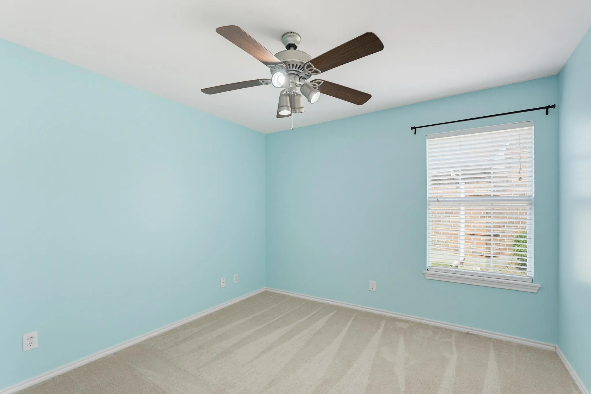 Ceiling fan with integrated lighting, window with blinds, and wall-to-wall carpeting