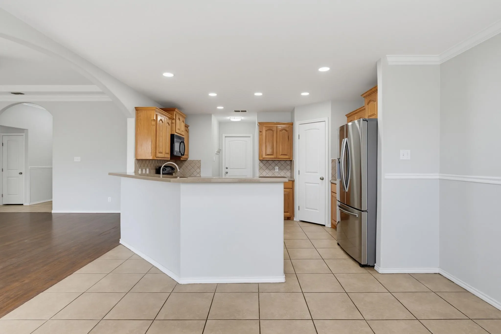 Kitchen featuring wood-finish cabinetry, stainless steel appliances, and a tiled backsplash