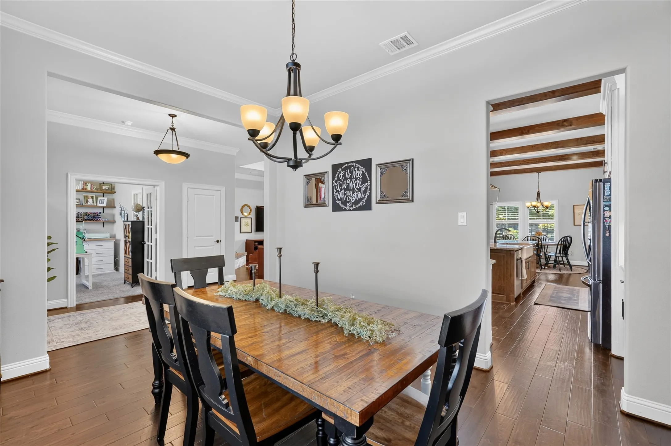 Elegant dining room featuring hardwood flooring, a wood-finish dining table, and black upholstered chairs